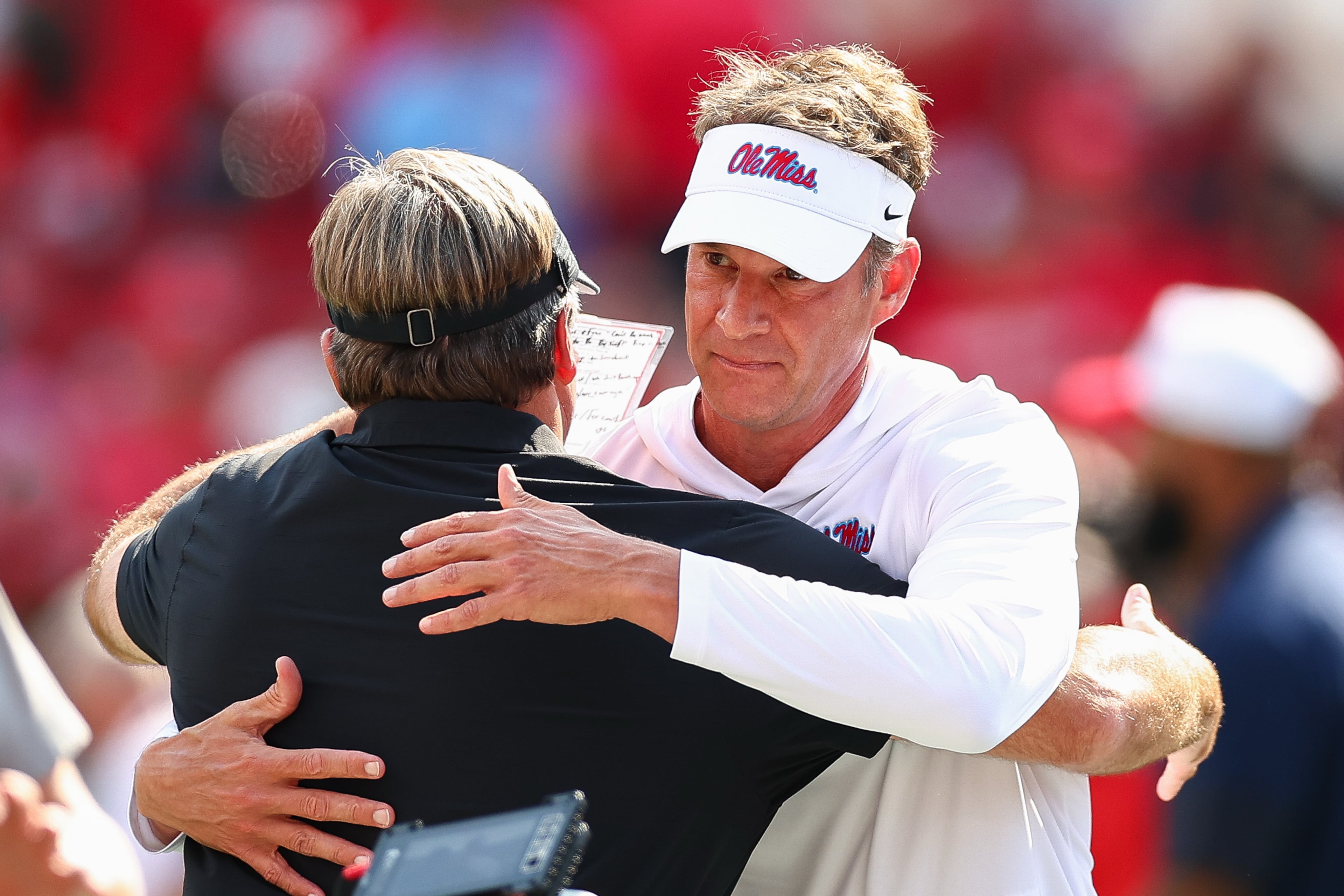 Georgia head coach Kirby Smart, left, and Mississippi head coach Lane Kiffin, right, meet during pregame warmups before the start of an NCAA college football game, Saturday, Oct. 18, 2025, in Athens, Ga. (AP Photo/Colin Hubbard)