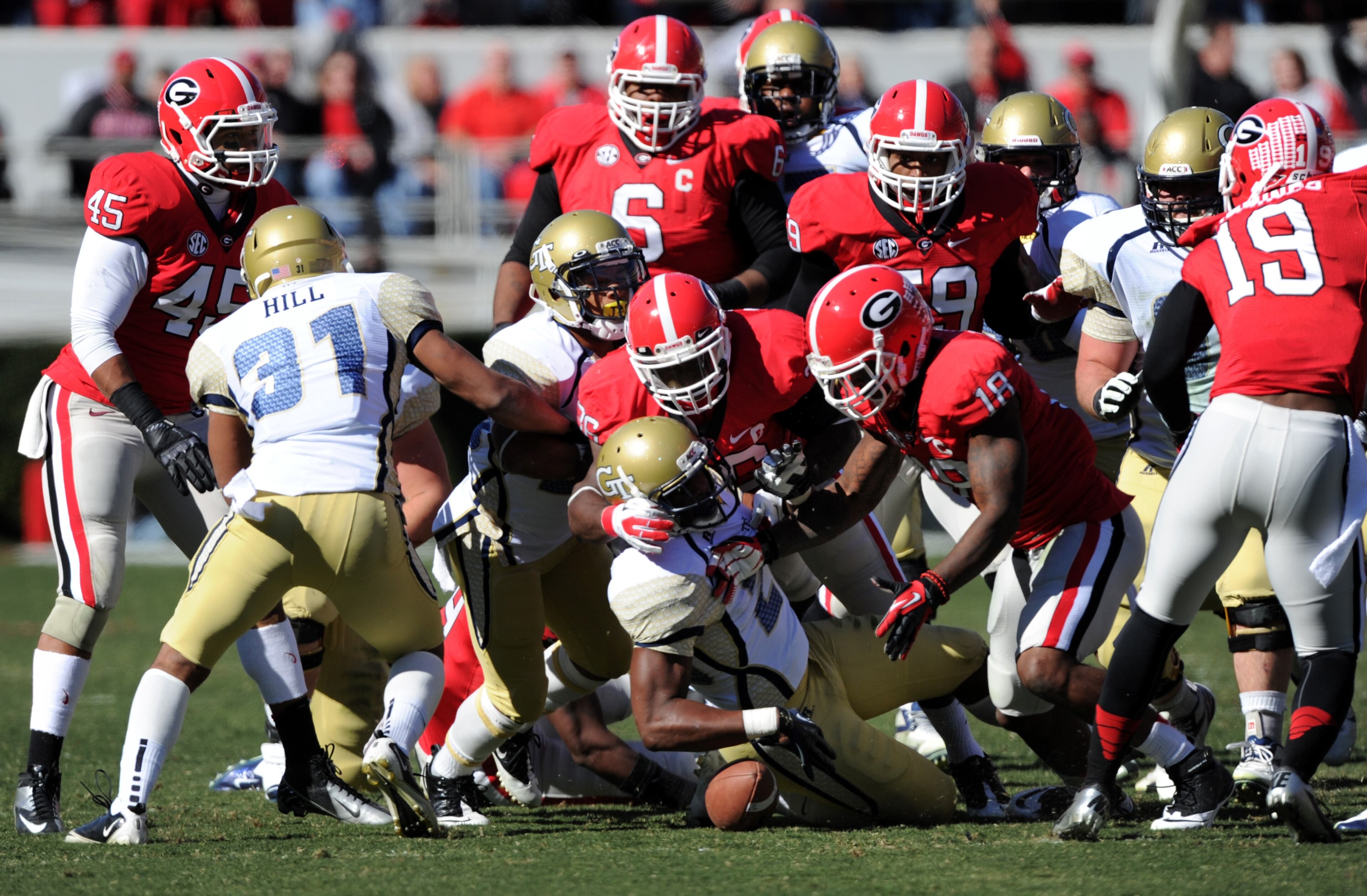 Georgia Tech running back David Sims (20) fumbles but recovers under pressure from Georgia's Bacarri Rambo (18) in the first quarter.