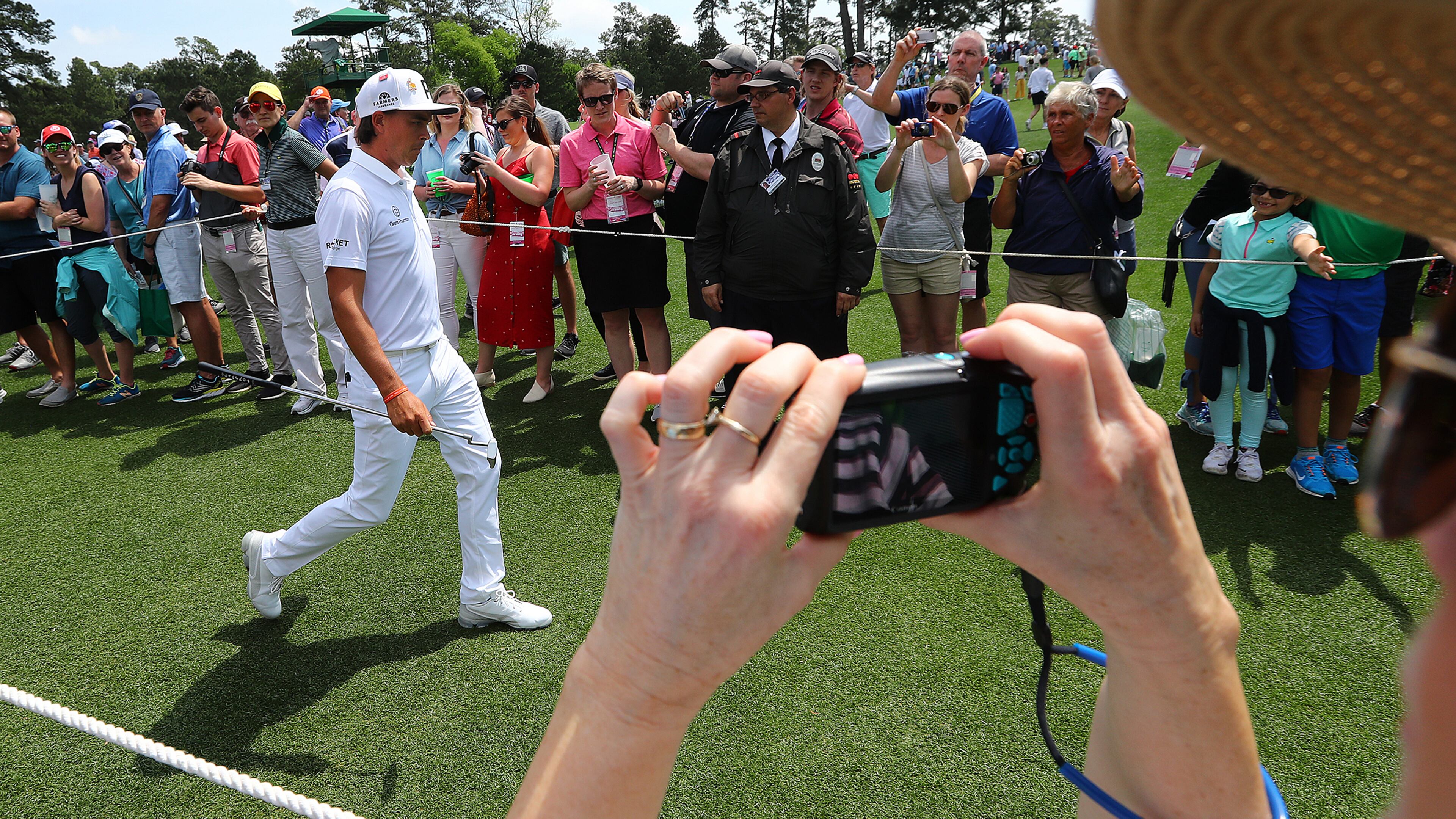 A fan snaps a photo of Rickie Fowler as he walks to the third tee box Monday, April 8, 2019, during his practice round for the Masters at Augusta National Golf Club in Augusta.