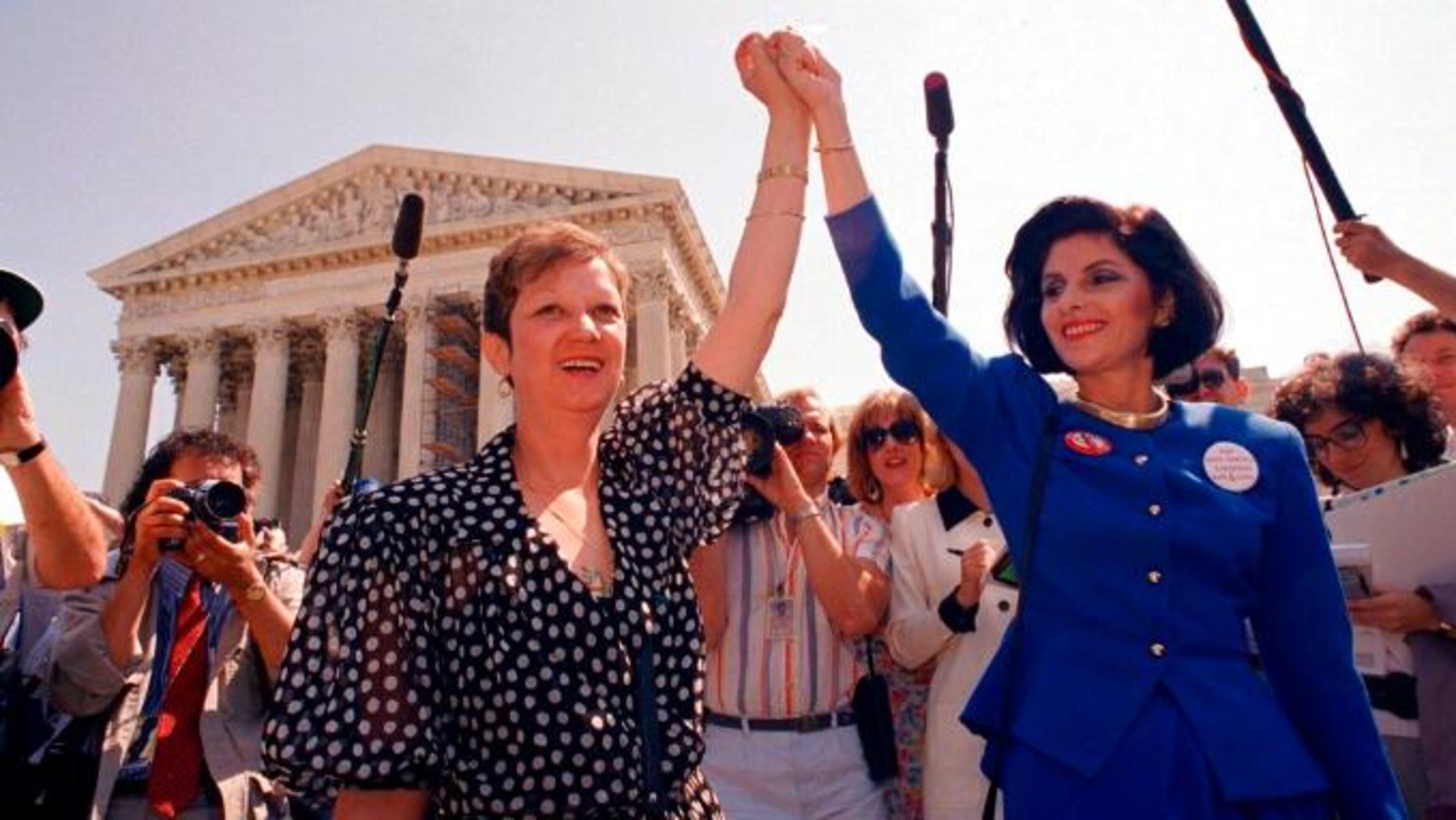 FILE - In this Wednesday, April 26, 1989 file photo, Norma McCorvey, Jane Roe in the 1973 court case, left, and her attorney Gloria Allred hold hands as they leave the Supreme Court building in Washington after sitting in while the court listened to arguments in a Missouri abortion case. (AP Photo/J. Scott Applewhite, File)