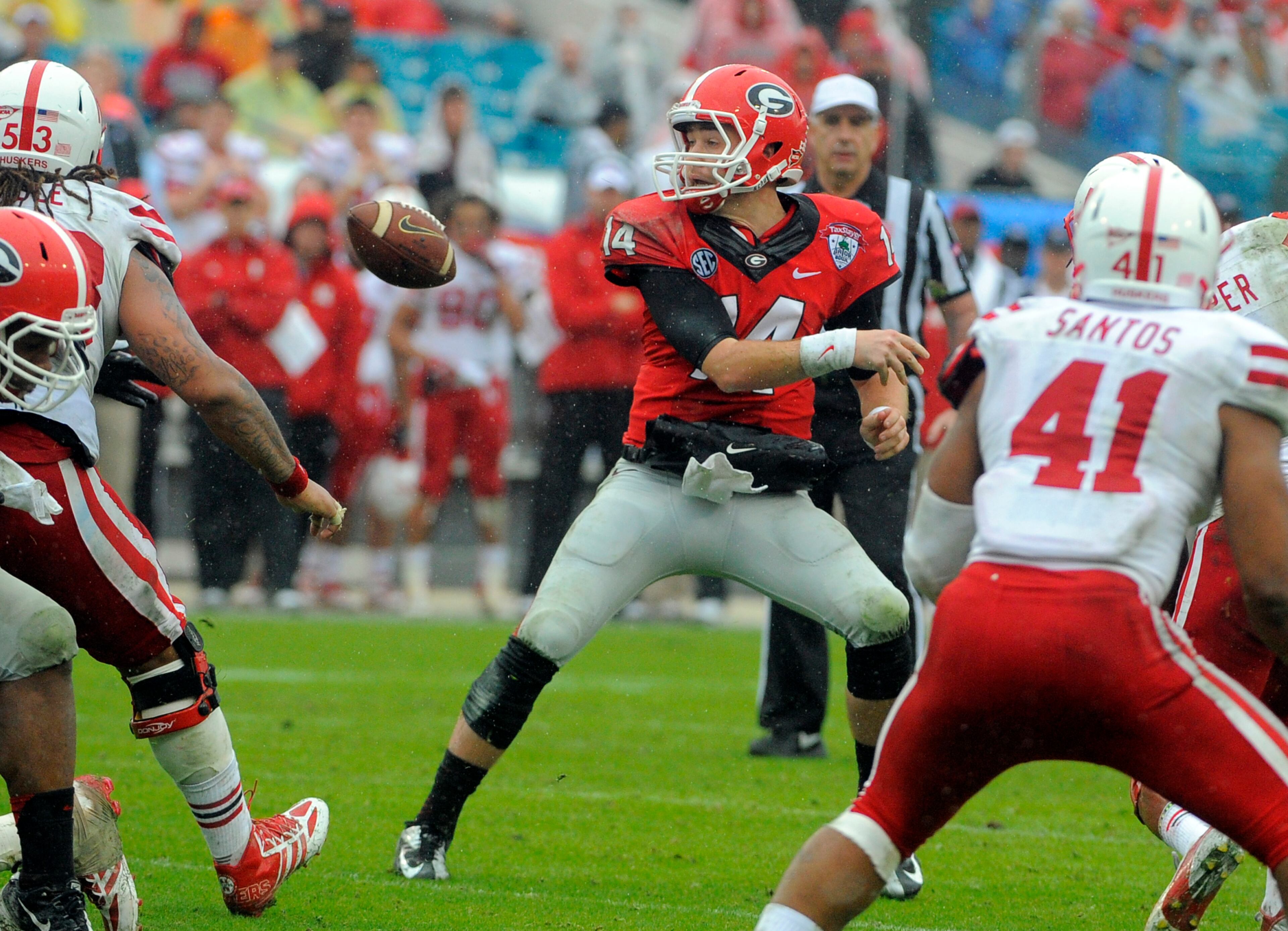 Georgia quarterback Hutson Mason (14) fumbles the ball during the second half of the Gator Bowl NCAA college football game against Nebraska, Wednesday, Jan. 1, 2014, in Jacksonville, Fla. Mason recovered his own fumble. Nebraska beat Georgia 24-19. (AP Photo/Stephen B. Morton)
