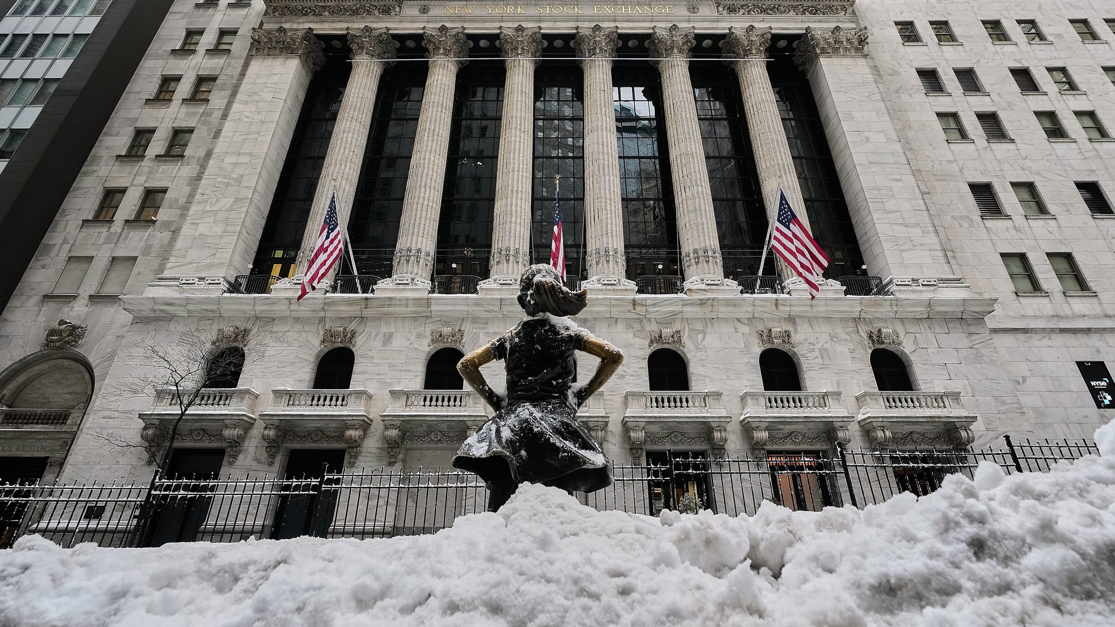 The Fearless Girl statue stands in the snow in front of the New York Stock Exchange, Monday, Jan. 26, 2026. (AP Photo/Richard Drew)