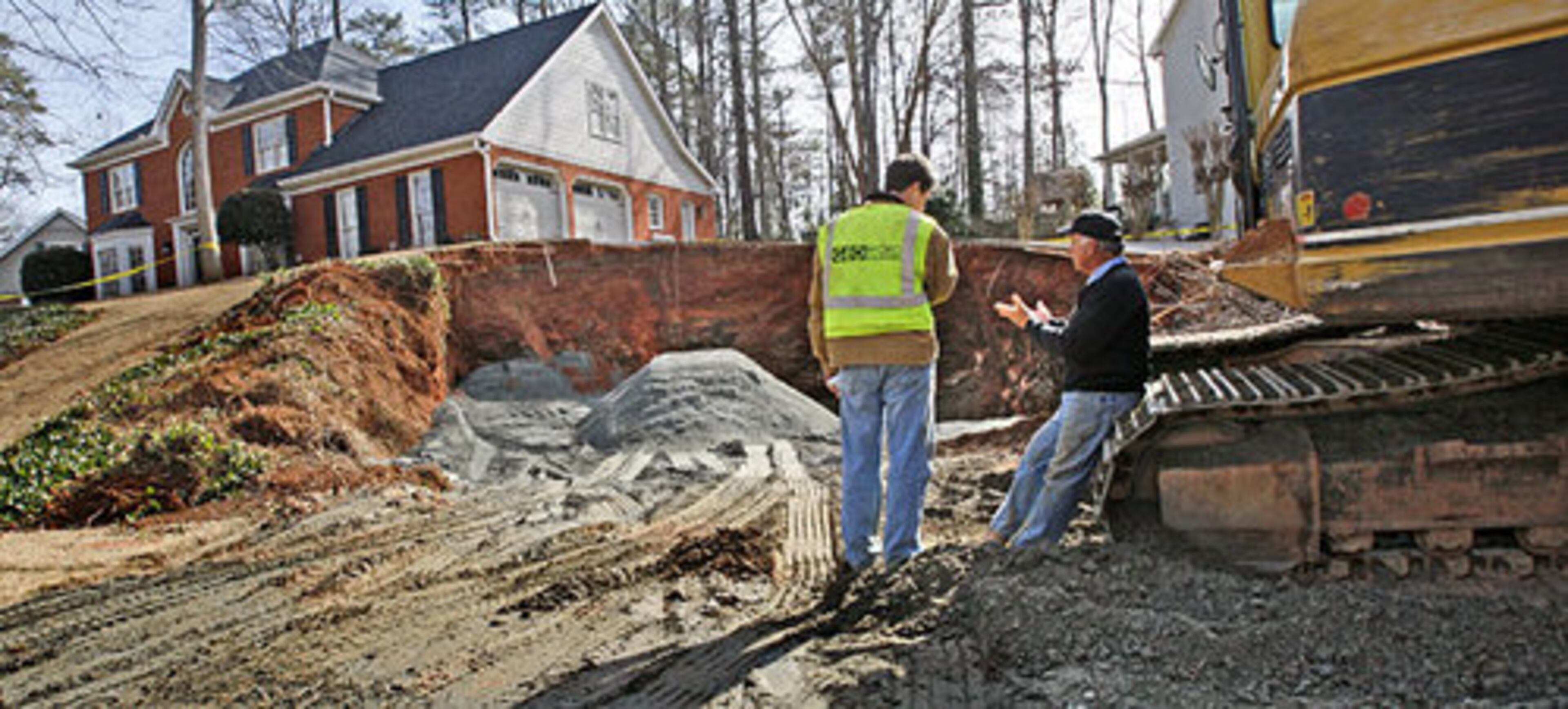 Marty Peniger with GEO Hydro engineers (left) speaks with operator, Wayne Marcinko of G.E.M. Contractors as they wait for another truck load of A-10 manufactured granite being used for the base that will be followed by dirt.