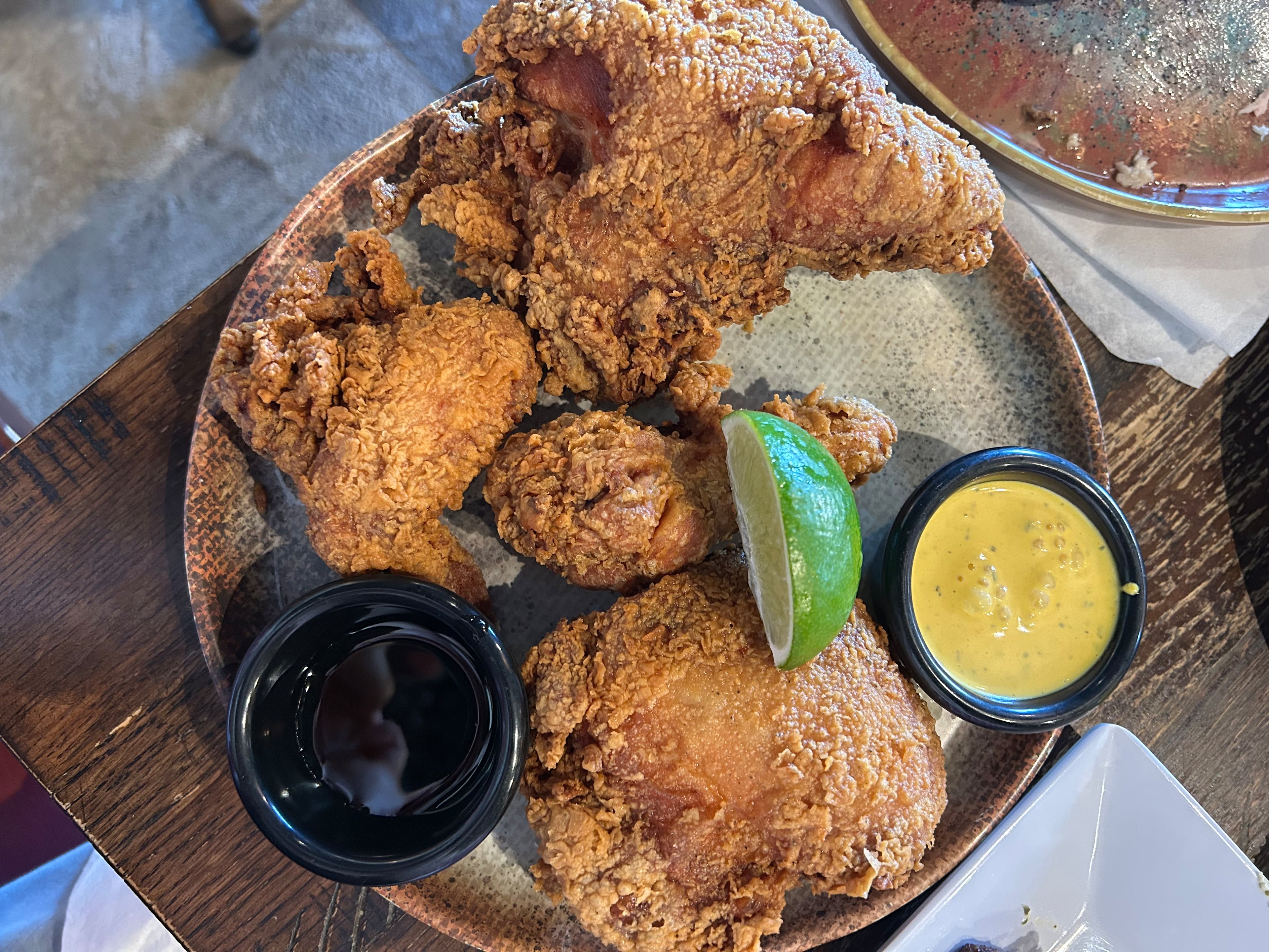 The pollo frito at Las Brasas is marinated for 12 hours in a beer and herb blend, and served with sauces and a wedge of lime. (Candy Hom for the AJC)