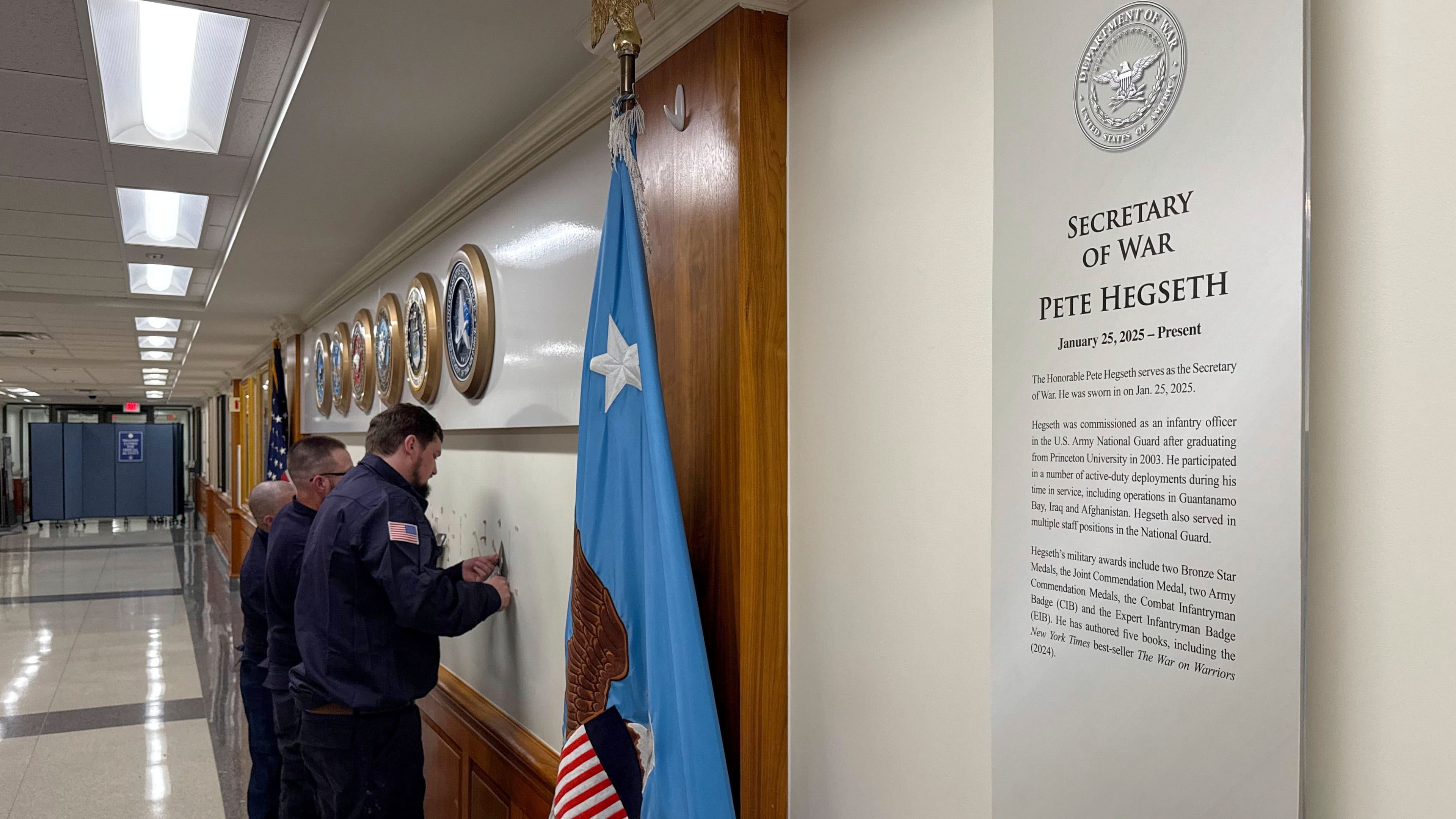 FILE - Workers remove sign lettering at the Pentagon after President Donald Trump signed an executive order aiming to rename the Department of Defense the Department of War in Washington, Sept. 5, 2025. (AP Photo/Mike Pesoli, File)