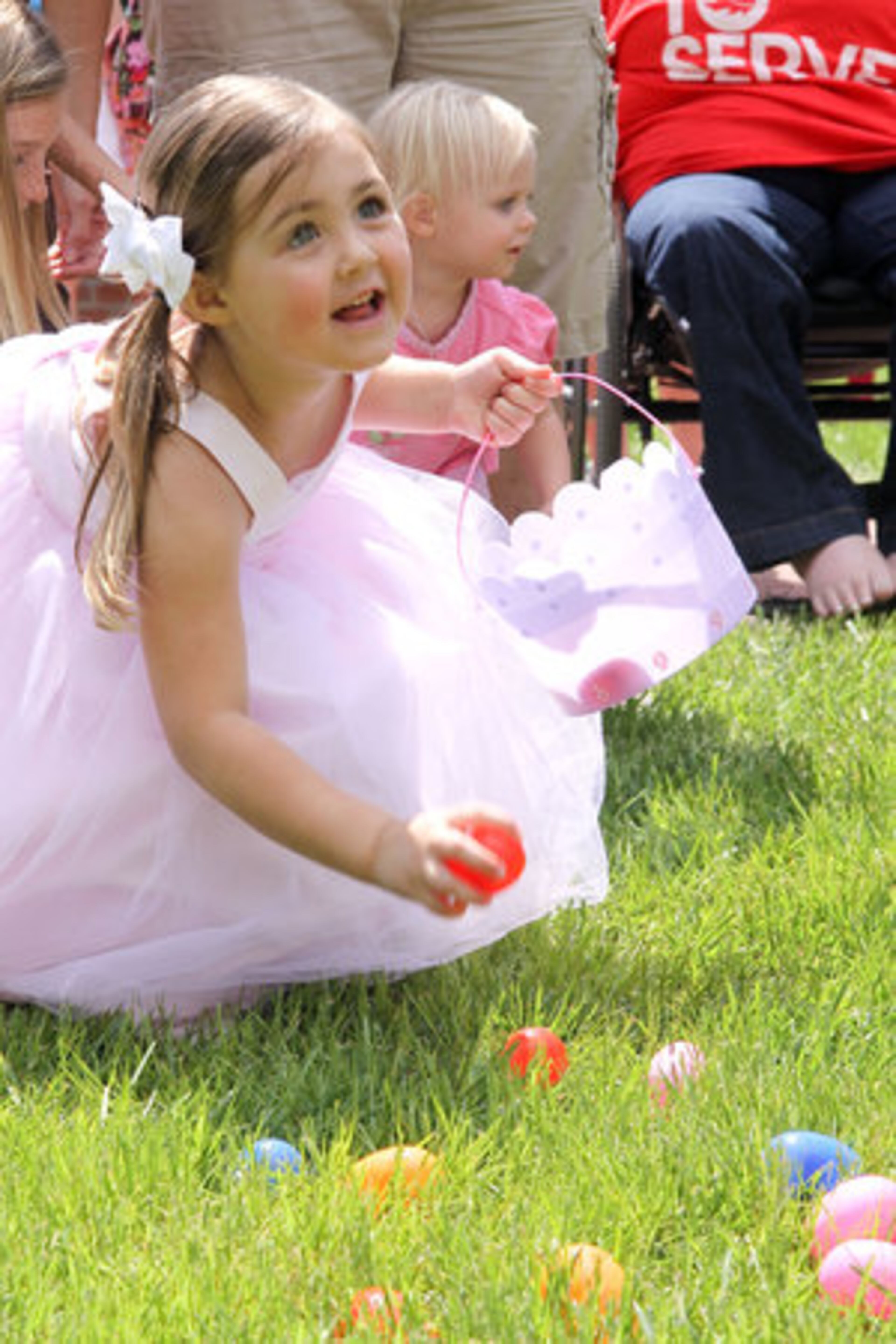 Leighton Longwell, 3, from Marietta fills her basket with Easter eggs during the Canton Easter Egg Festival in historic downtown Canton on Saturday, April 7, 2012.