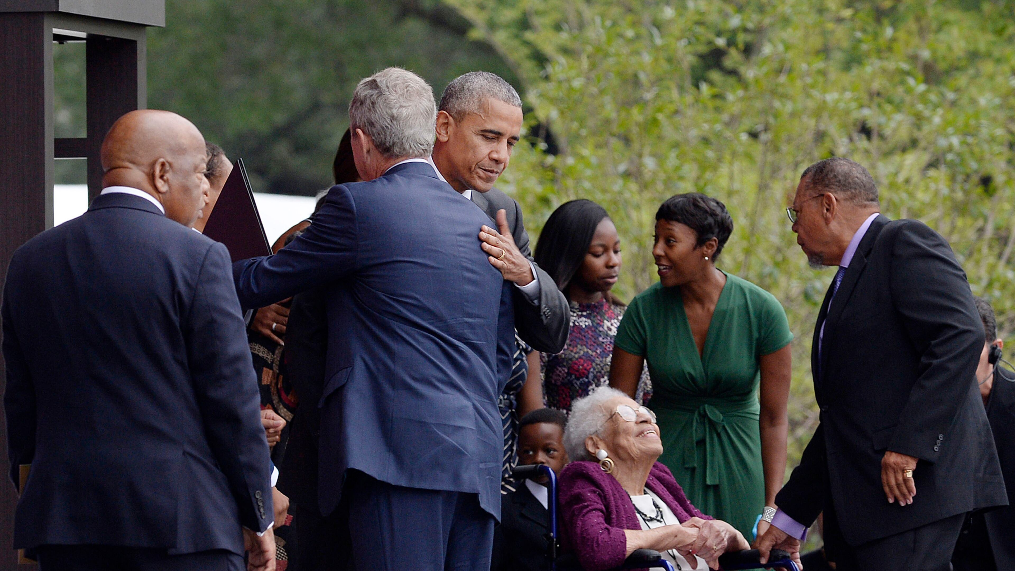 President Obama hugs former President George W. Bush as Rep. John Lewis, left, looks on during the opening ceremony of the Smithsonian National Museum of African American History and Culture on Saturday, Sept. 24, 2016, in Washington, D.C. (Olivier Douliery/Abaca Press/TNS)