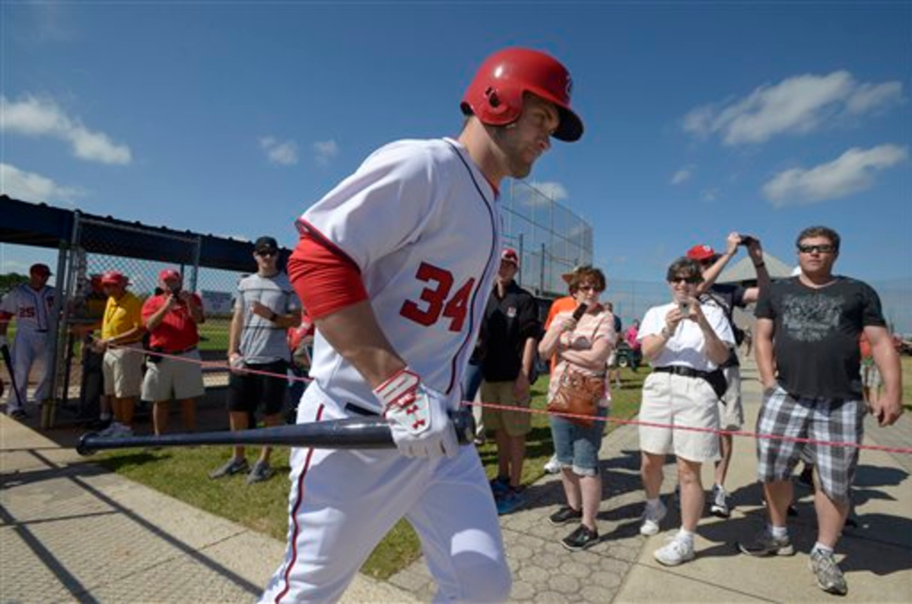 Washington Nationals outfielder Bryce Harper runs past fans while changing to a different field during spring training baseball in Viera, Fla., Wednesday, Feb. 20, 2013.(AP Photo/Phelan M. Ebenhack)
