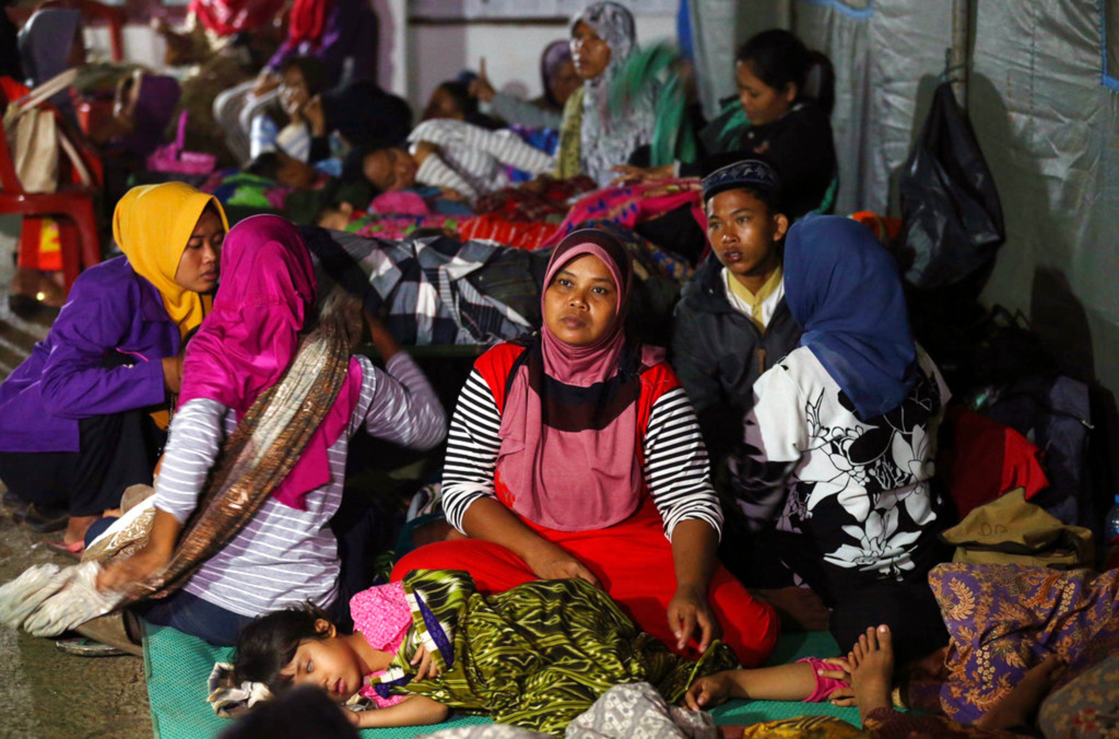 Tsunami survivors gather at temporary shelter in Tanjung Lesung, Indonesia, Sunday, Dec. 23, 2018. The tsunami occurred after the eruption of a volcano around Indonesia's Sunda Strait during a busy holiday weekend, sending water crashing ashore and sweeping away hotels, hundreds of houses and people attending a beach concert. (AP Photo/Achmad Ibrahim)