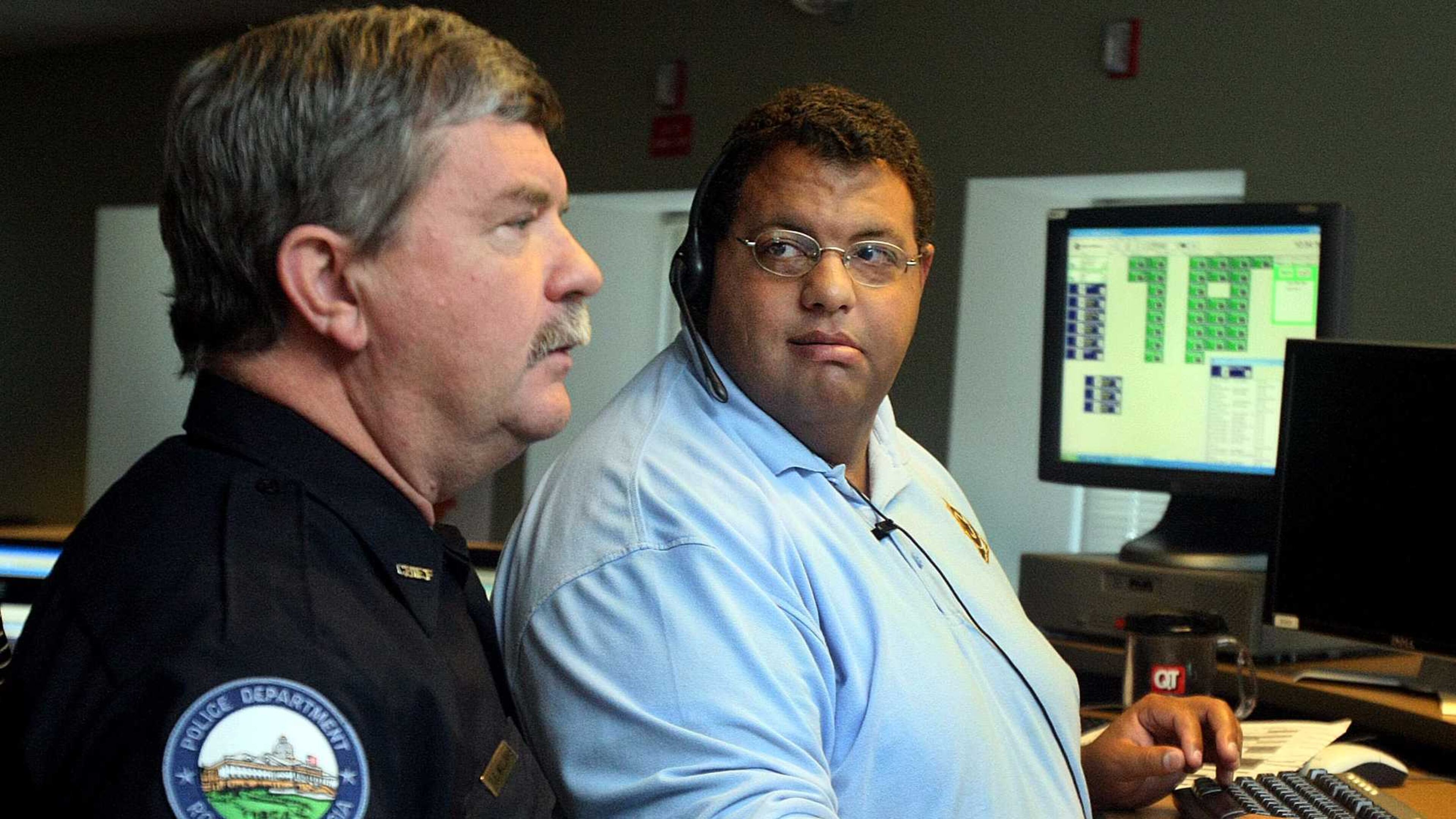 Roswell Police Chief Edwin Williams chats with Communications Officer Chad Jenkins in the Roswell 911 Center in August 2010.