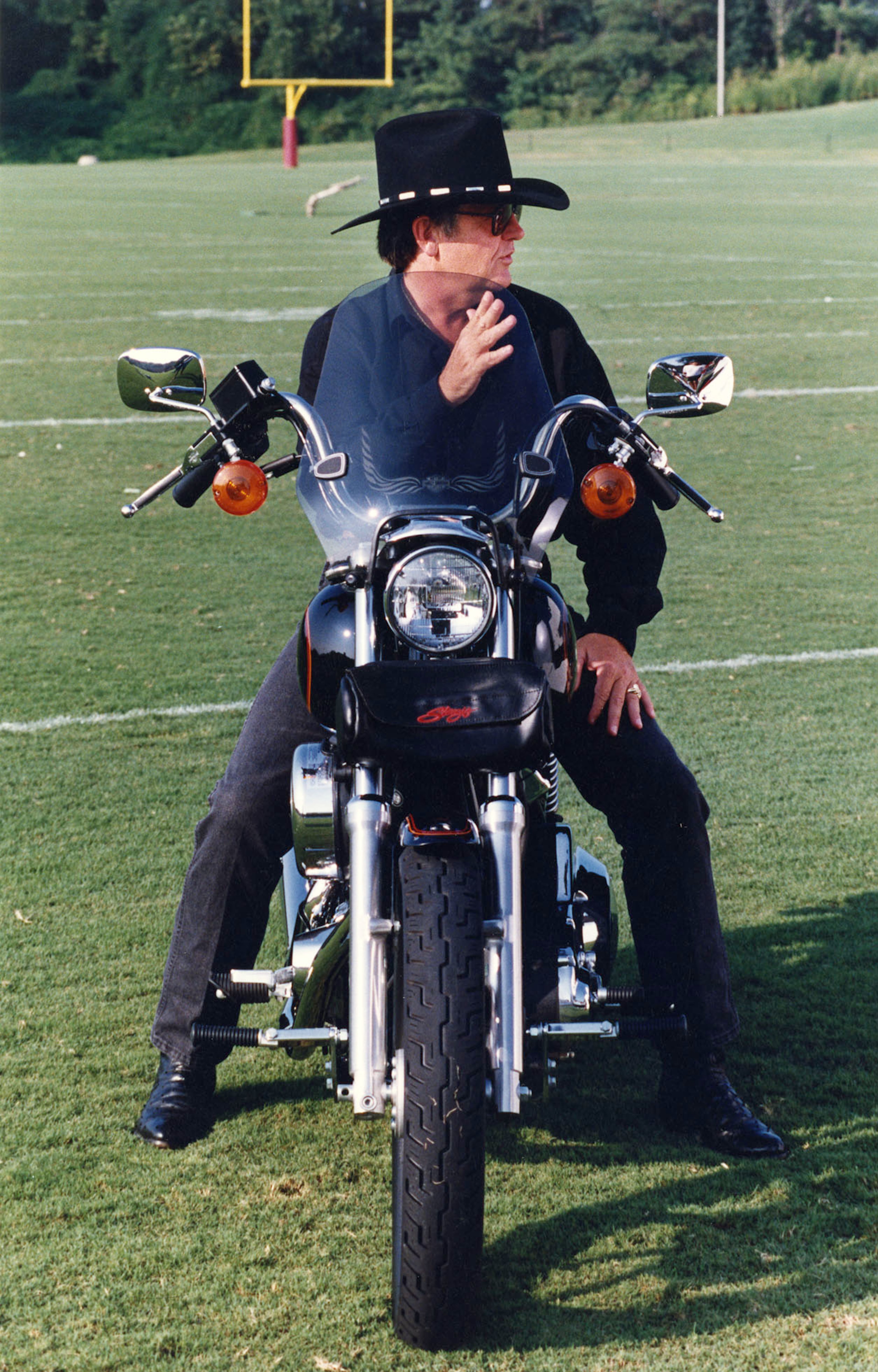 Glanville sits on a motorcycle at Falcons training camp in 1991 while being filmed for part of an MC Hammer video. W.A. Bridges Jr. / AJC file photo