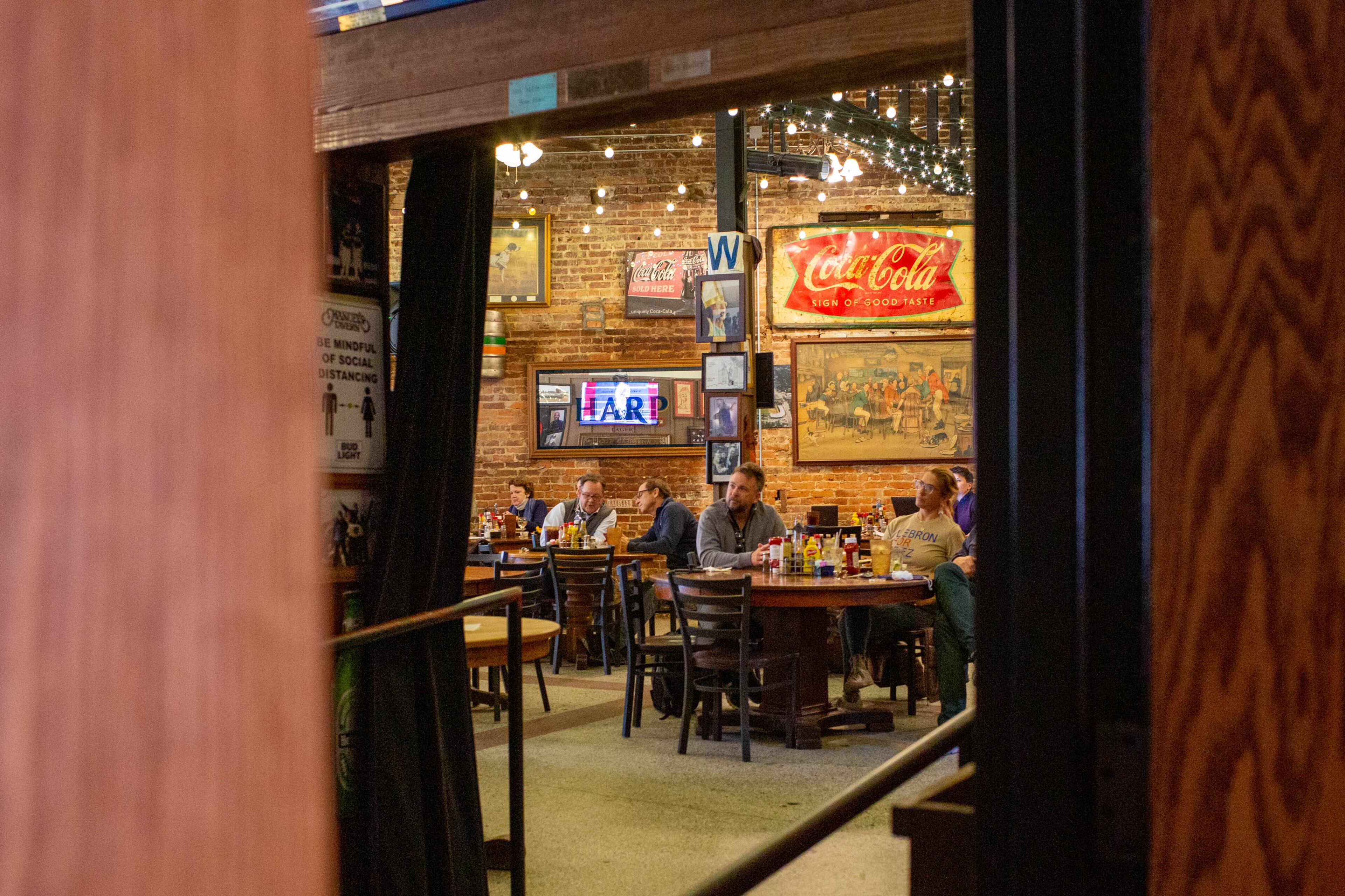People watch the inauguration of Joe Biden at an Inauguration watch party in Atlanta, Georgia, on Wednesday, January 20, 2021. Manuel’s Tavern held an Inauguration watch party on Wednesday to celebrate the election of President Joe Biden. (Rebecca Wright for the Atlanta Journal-Constitution)