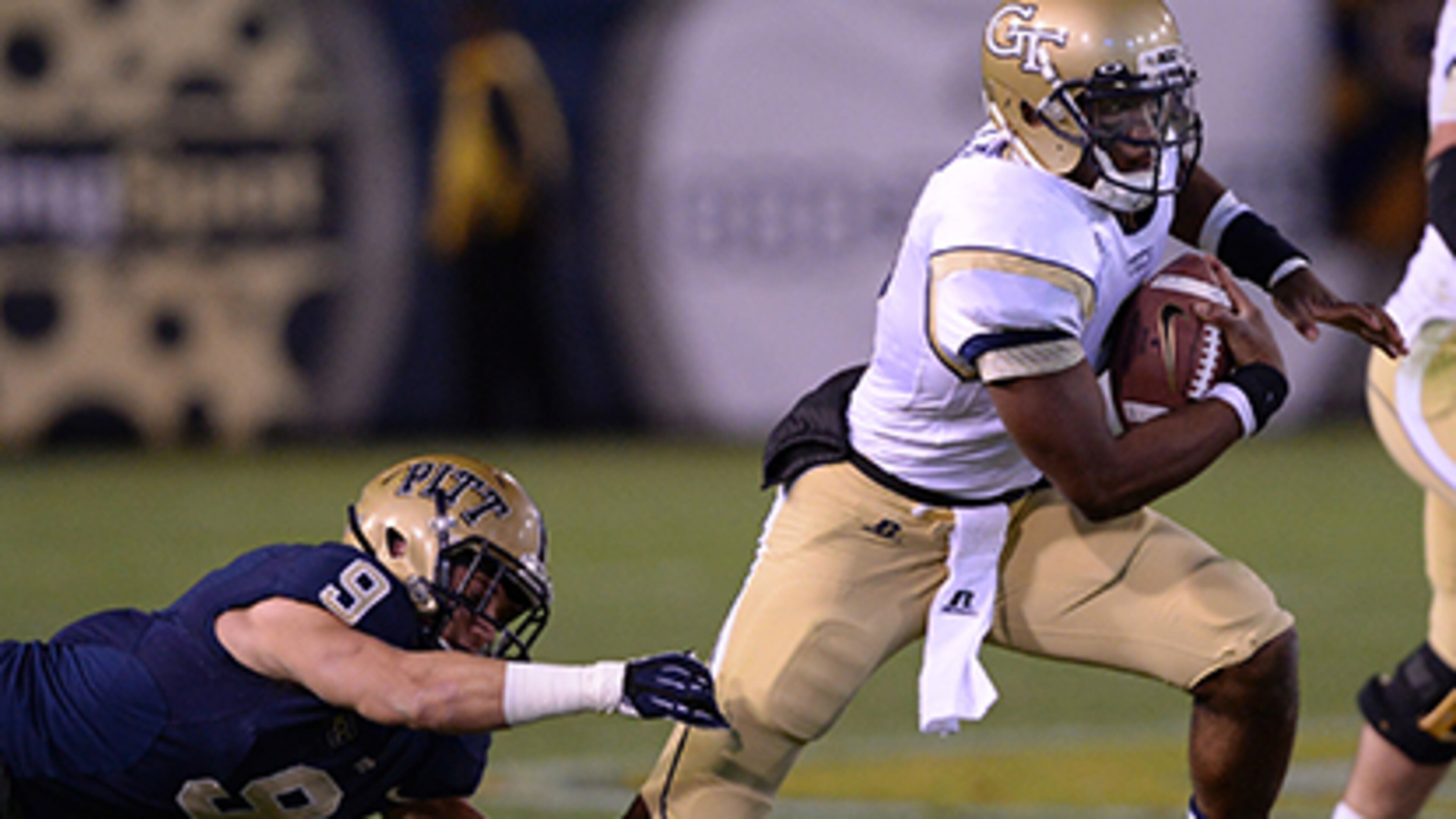November 2, 2013 - Atlanta: Georgia Tech quarterback Vad Lee escapes from Pittsburgh's Ray Vinopal (9) in the first quarter in Bobby Dodd Stadium on Saturday, November 2, 2013. JOHNNY CRAWFORD / JCRAWFORD@AJC.COM