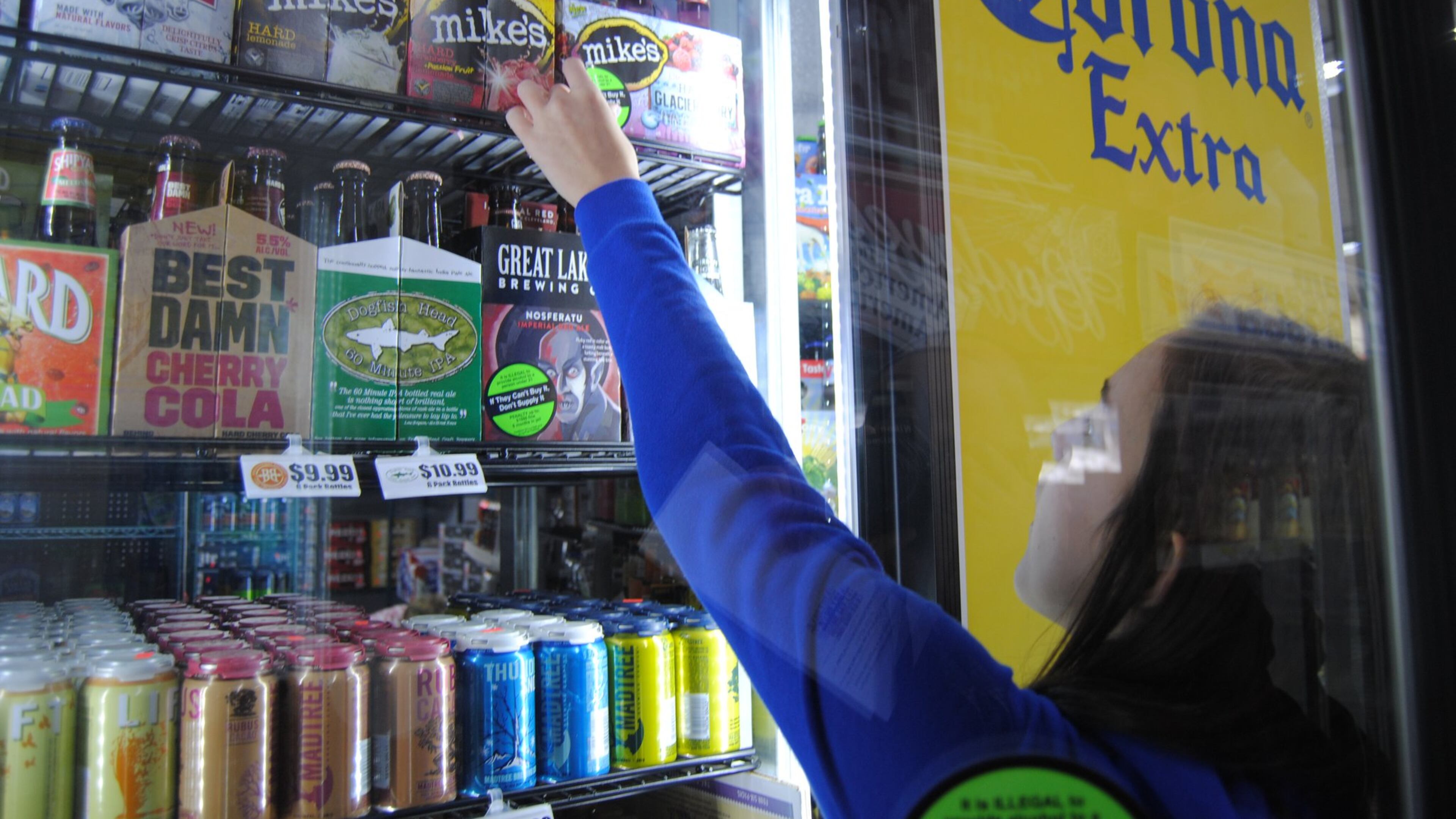 Fairfield High School Youth Coalition member Lindsey Ollis affixes warning labels to multipack containers of beer and wine coolers at Dixie Foodmart on Ohio 4 in Fairfield Sunday, March 20, 2016. The effort was the first installment in 2-day Sticker Shock initiative launched by Coalition for a Safe and Drug-Free Fairfield to educate the public and change attitudes about buying for and serving alcohol to anyone under the age of 21. ERIC SCHWARTZBERG/STAFF