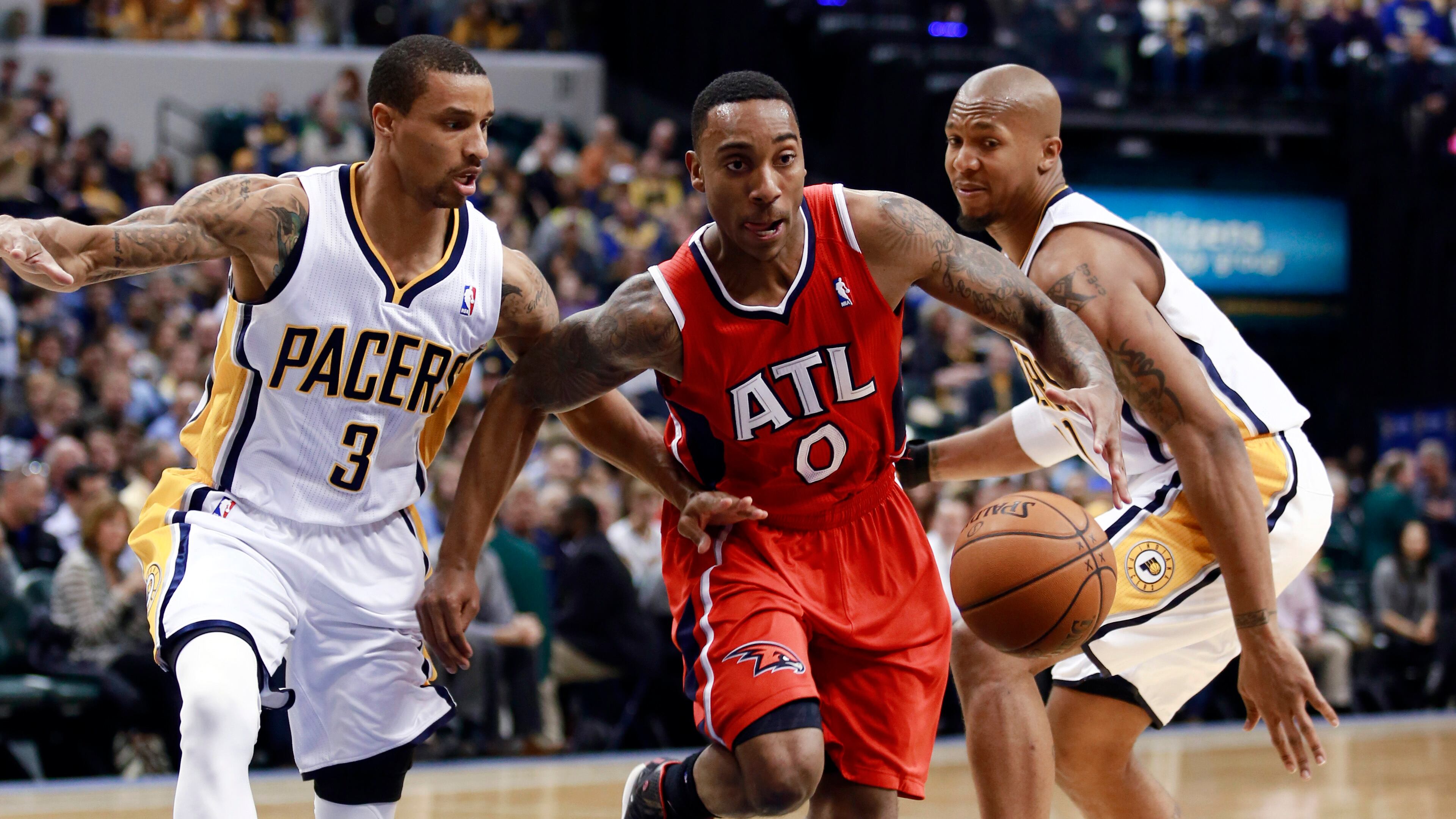 Atlanta Hawks guard Jeff Teague (0) retrieves the basketball after driving between Indiana Pacers guard George Hill (3) and forward David West during the first half of an NBA basketball game in Indianapolis, Tuesday, Feb. 18, 2014.