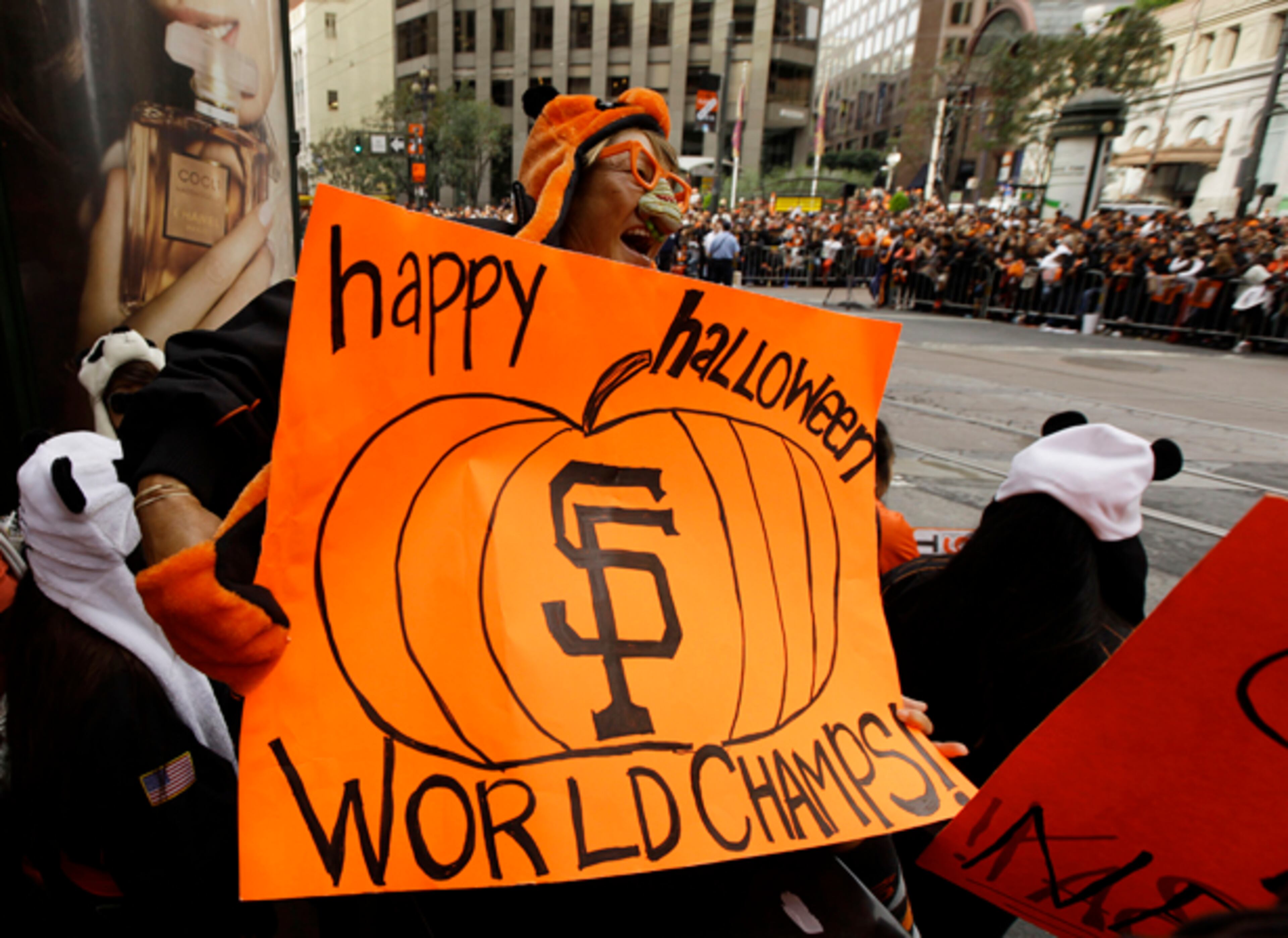Pearl Garvin, of Mountain View, Calif., holds a sign while waiting on Market Street for the start of the San Francisco Giants World Series victory parade Wednesday, Oct. 31, 2012, in San Francisco. The team's second championship in three years goes along Market Street and ends with a celebration in front of City Hall. (AP Photo/Eric Risberg)