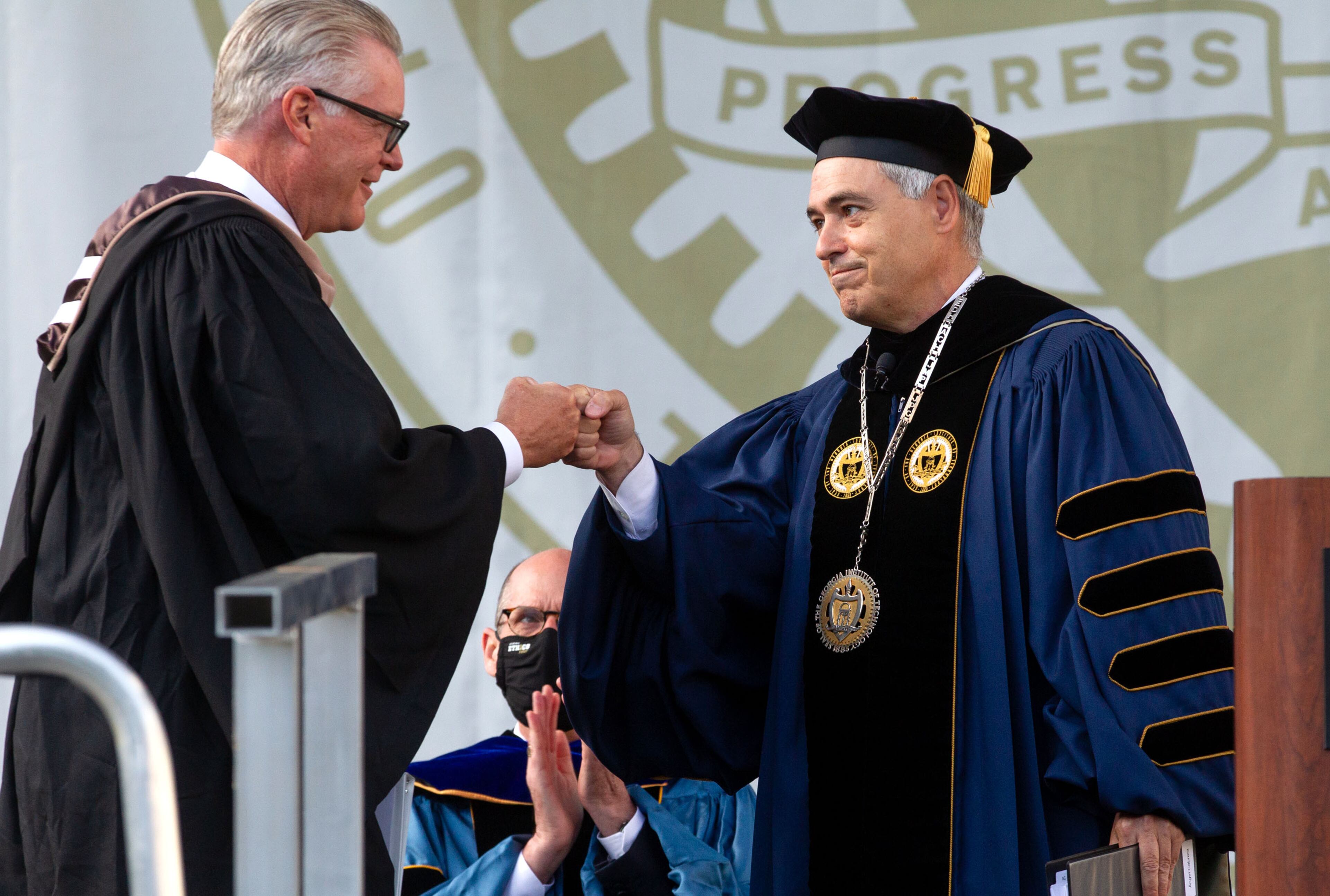 Georgia Tech President Ángel Cabrera gives Delta Air Lines CEO Ed Bastian a fist-bump after introducing him during the 2021 commencement ceremony at Bobby Dodd Stadium on Saturday, May 8, 2021. (Photo: Steve Schaefer for The Atlanta Journal-Constitution)