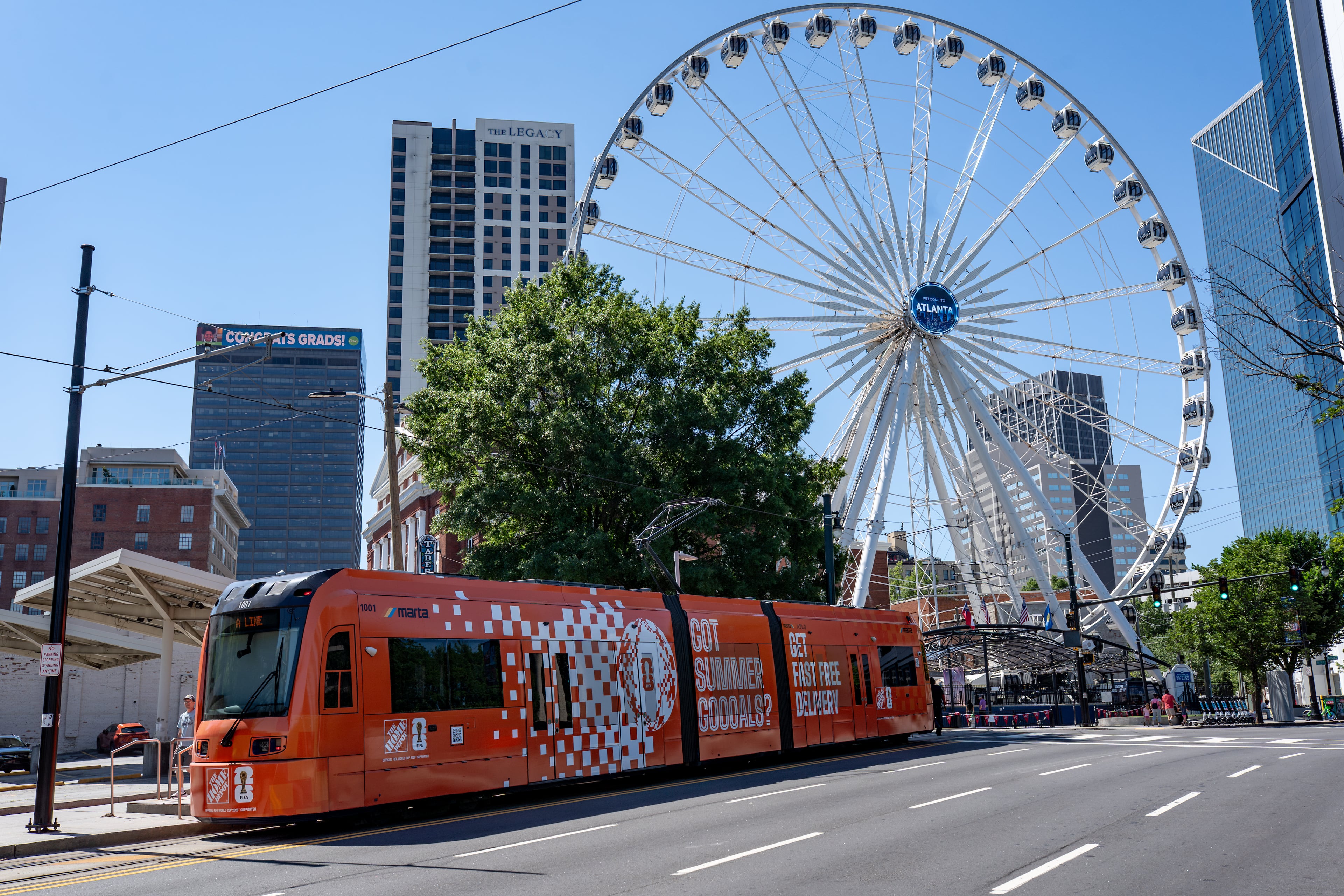 An Atlanta streetcar makes a stop along Cenntenial Olympic Park Drive with a FIFA-related Home Depot ad covering the train on Thursday, June 4, 2026. (Ben Hendren for the AJC)