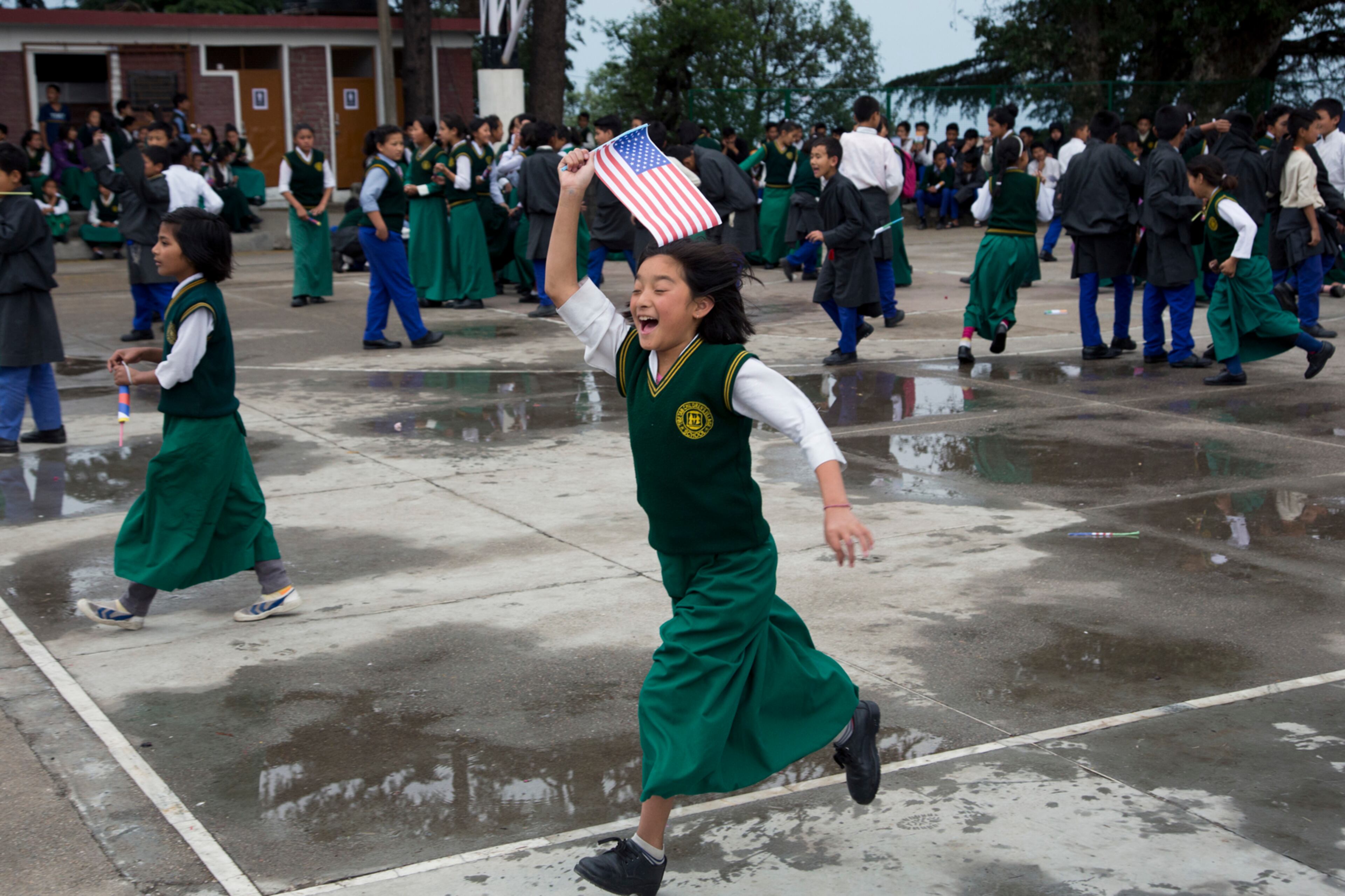 An exile Tibetan girl runs with a U.S. flag as she waits to welcome Democratic leader in the U.S. House of Representatives Nancy Pelosi at the Tibetan Children's Village School in Dharmsala, India, Tuesday, May 9, 2017. Pelosi is leading a bipartisan congressional delegation on a two-day trip to Dharmsala. (AP Photo/Ashwini Bhatia)