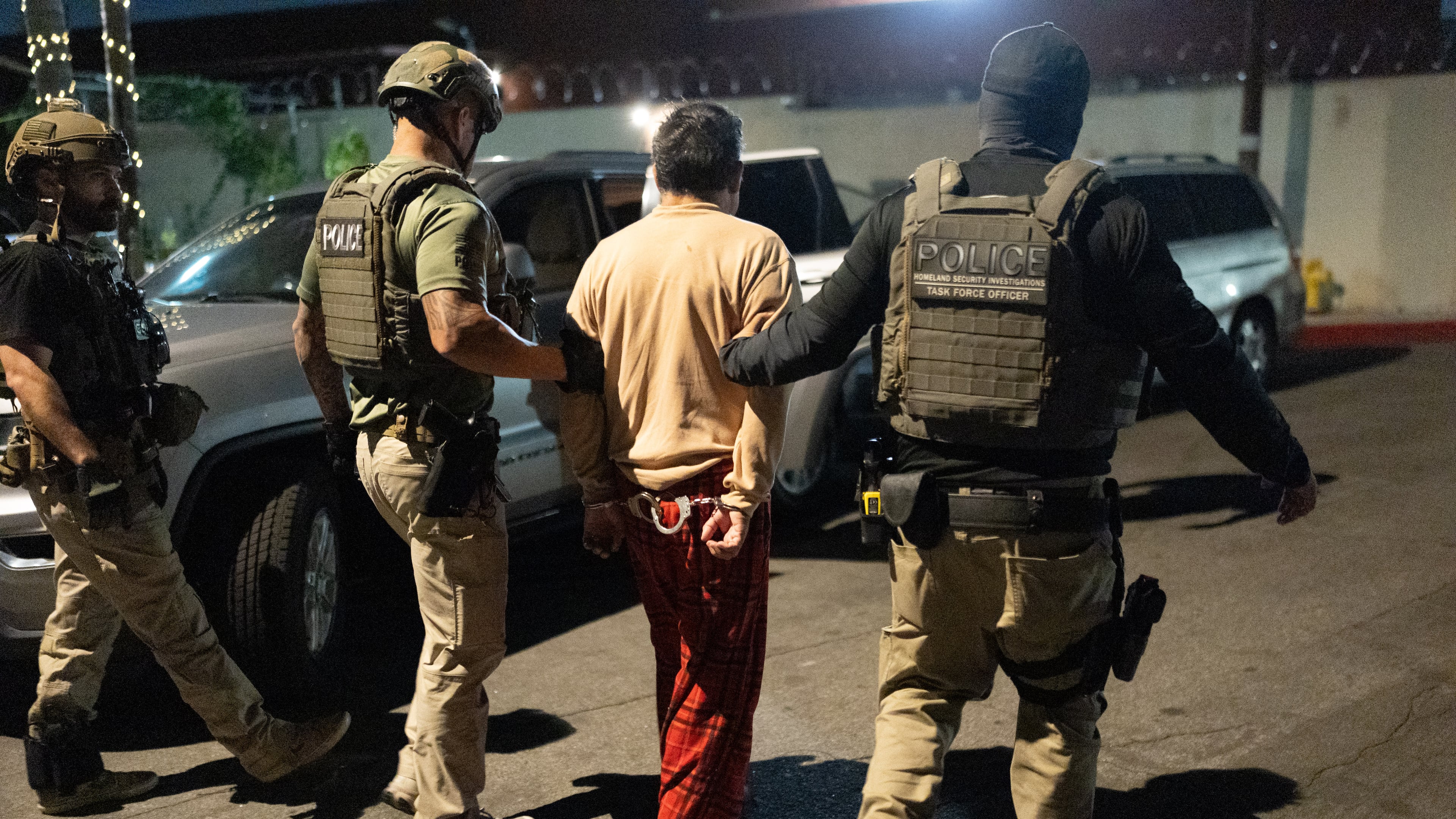Homeland Security Investigations task force officers escort a suspect accused of illegally registering to vote during a federal operation in Commerce, Calif., Monday, Oct. 19, 2026. (AP Photo/Jae C. Hong)
