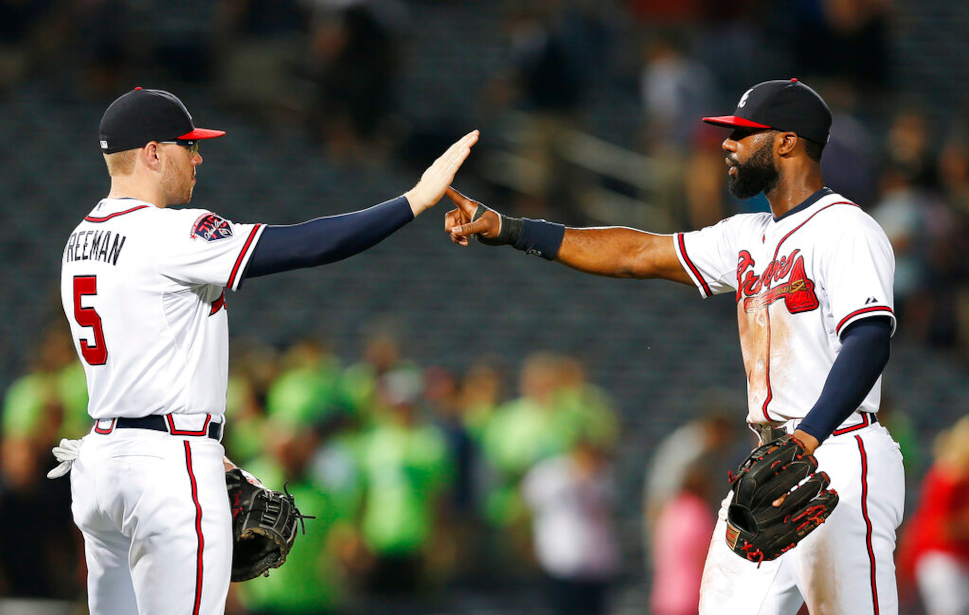 Atlanta Braves' Freddie Freeman, left, and Jason Heyward celebrate after defeating the Miami Marlins 6-1 in baseball game in Atlanta, Wednesday, July 23, 2014. (AP Photo)