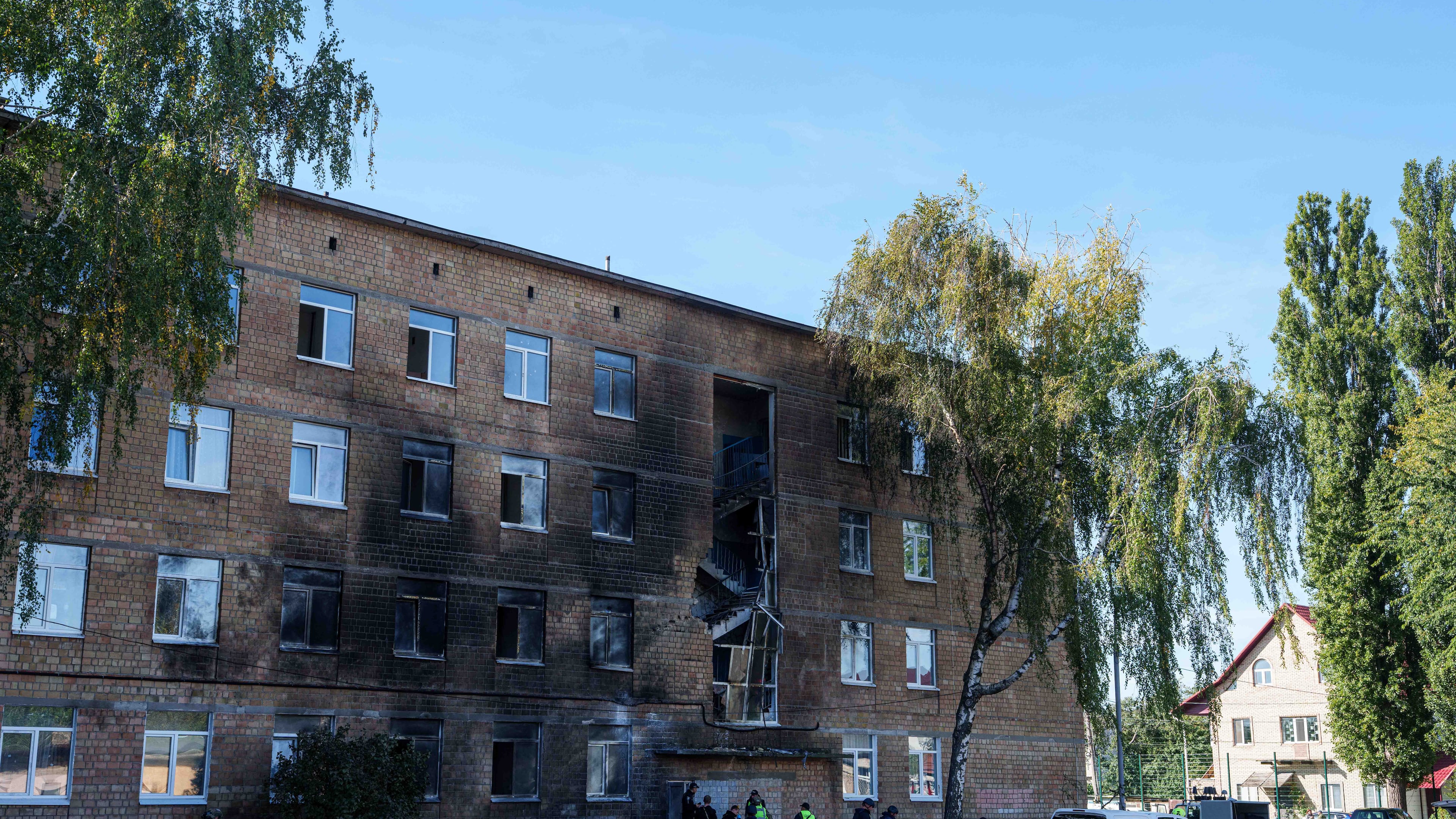 Police officers look at a school damaged by a Russian drone strike in Kyiv, Ukraine, Thursday, Oct. 1, 2026. (AP Photo/Evgeniy Maloletka)