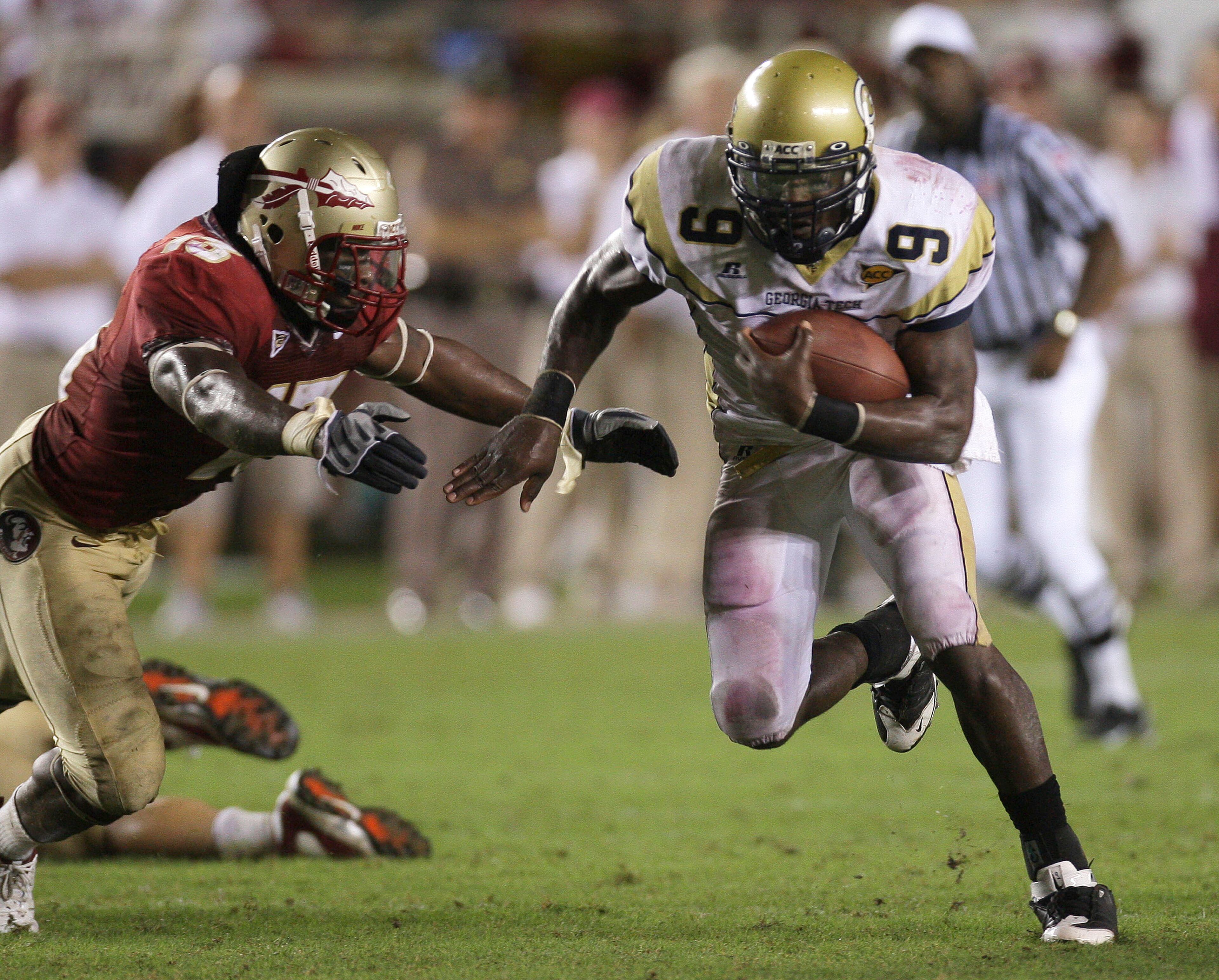 Georgia Tech quarterback Josh Nesbitt, right, runs for fourth quarter yardage as Florida State's Nigel Bradham, left, attempts to make the tackle during an NCAA college football game, Saturday, Oct. 10, 2009, in Tallahassee, Fla. Georgia Tech won 49-44. (AP Photo/Phil Coale)