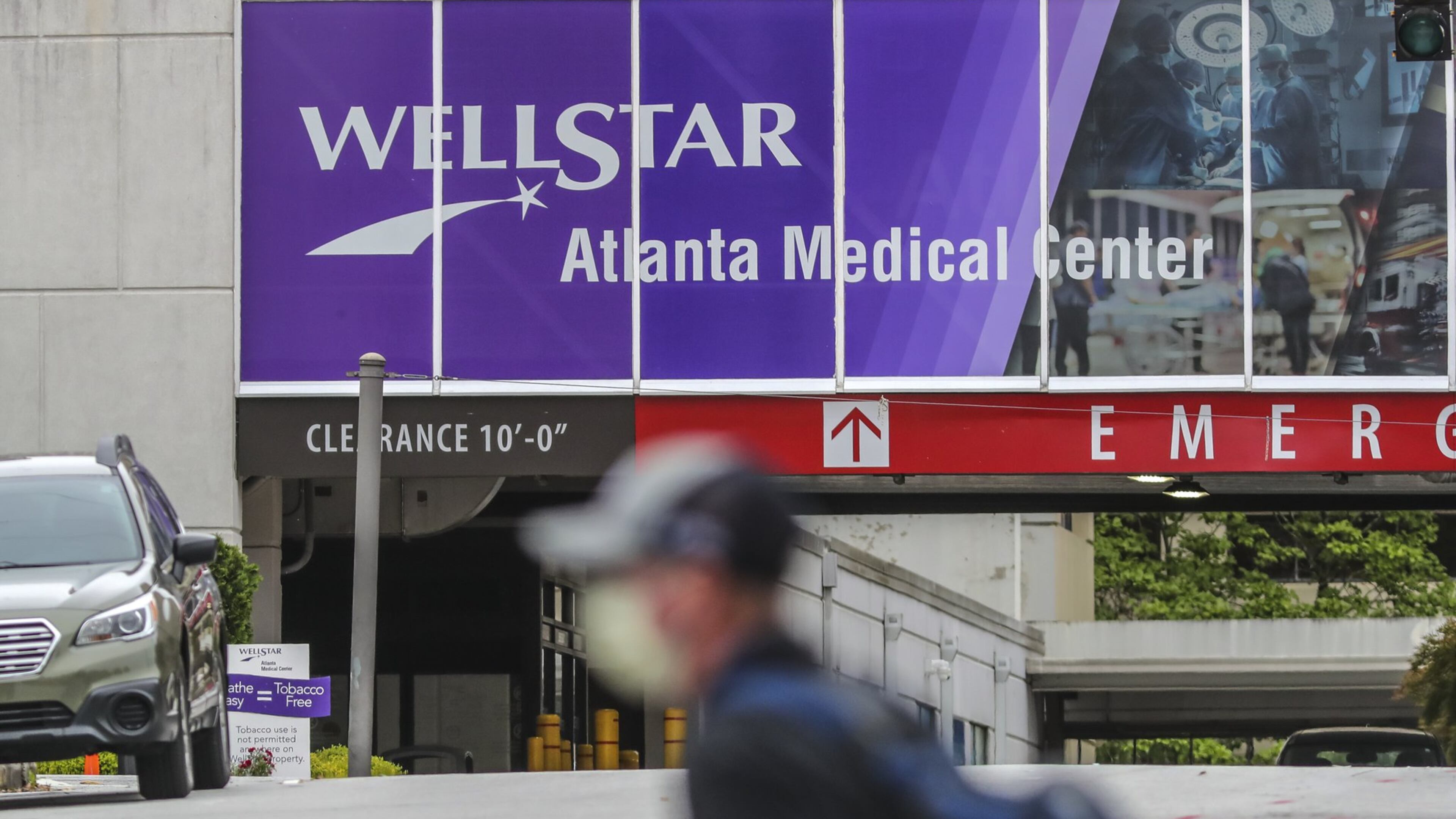 A man walks past Wellstar Atlanta Medical Center in Atlanta on Wednesday. The Wellstar system has announced it is furloughing more than 1,000 employees across its network. (JOHN SPINK/JSPINK@AJC.COM)