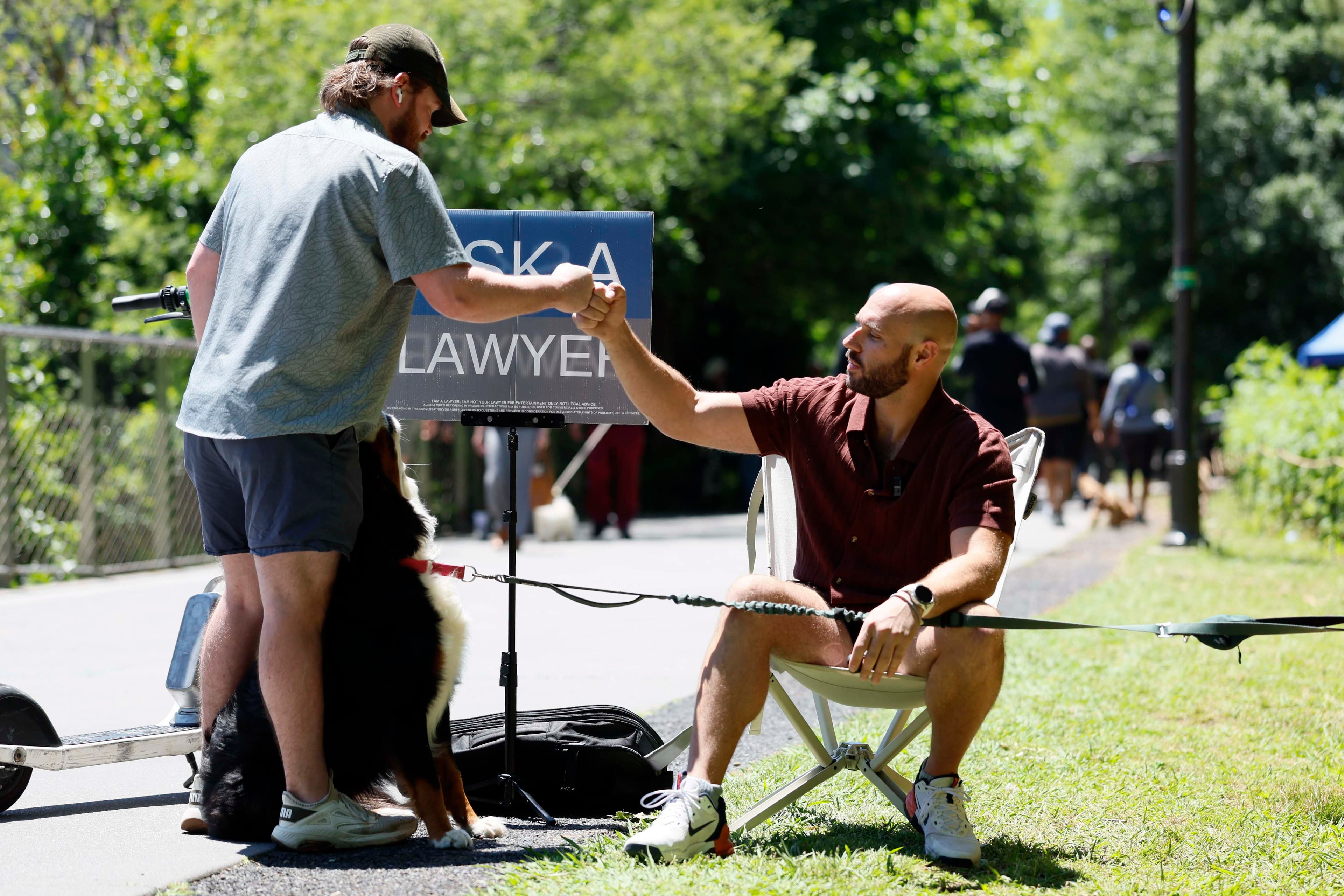 A Beltline visitor pauses to greet Atlanta attorney Cody Randall and his 6-year-old Bernese Mountain Dog, Reba, on Sunday, May 3, 2026. Randall says "anyone and everyone" approaches him with questions, both personal and general, now that he's a social media star with 1.5 million followers. (Miguel Martinez/AJC)