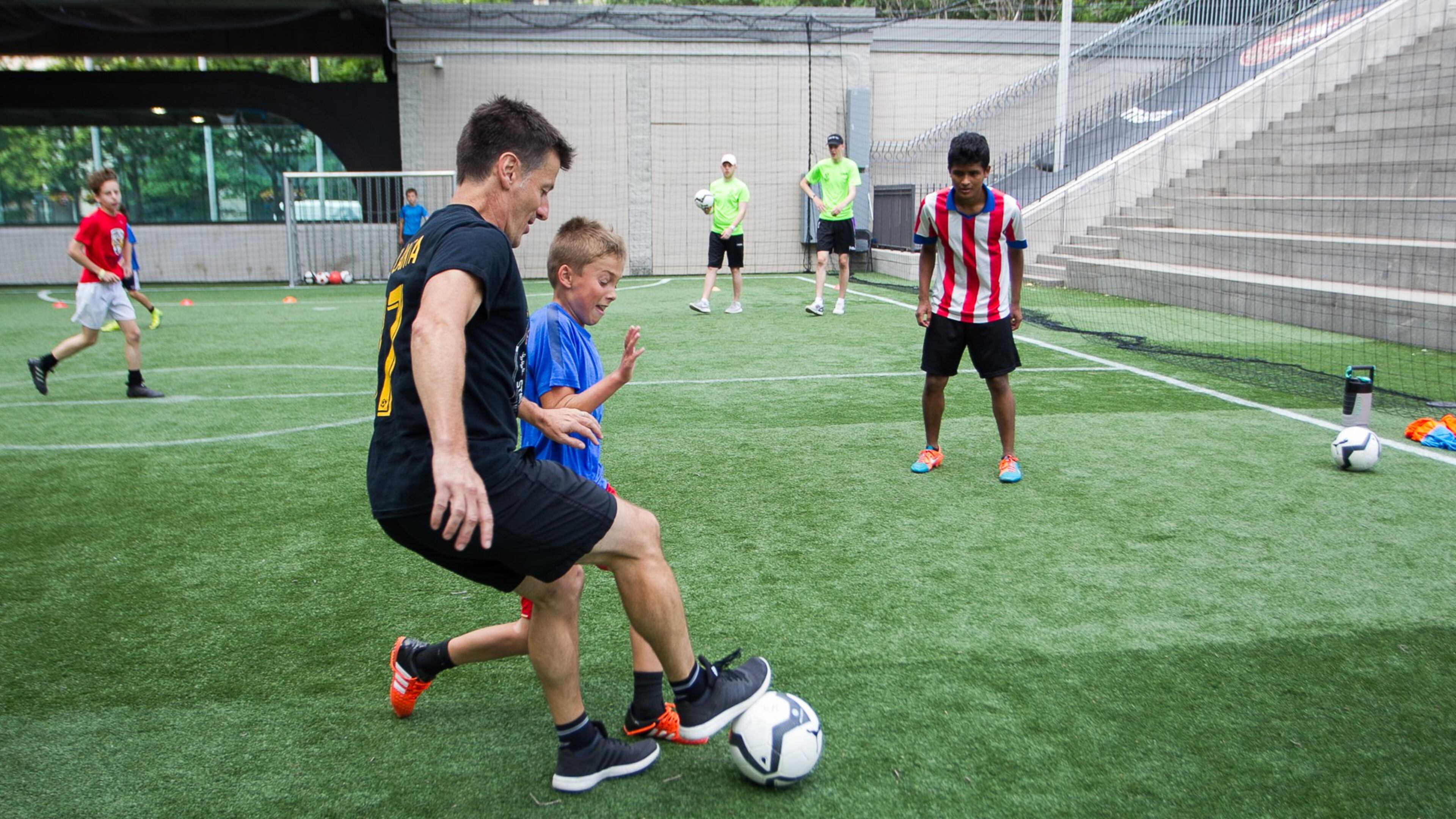 Phil Hill, executive director of Soccer in the Streets, mixes it up with kids at a summer camp at the Five Points MARTA Station. DAVE WILLIAMSON