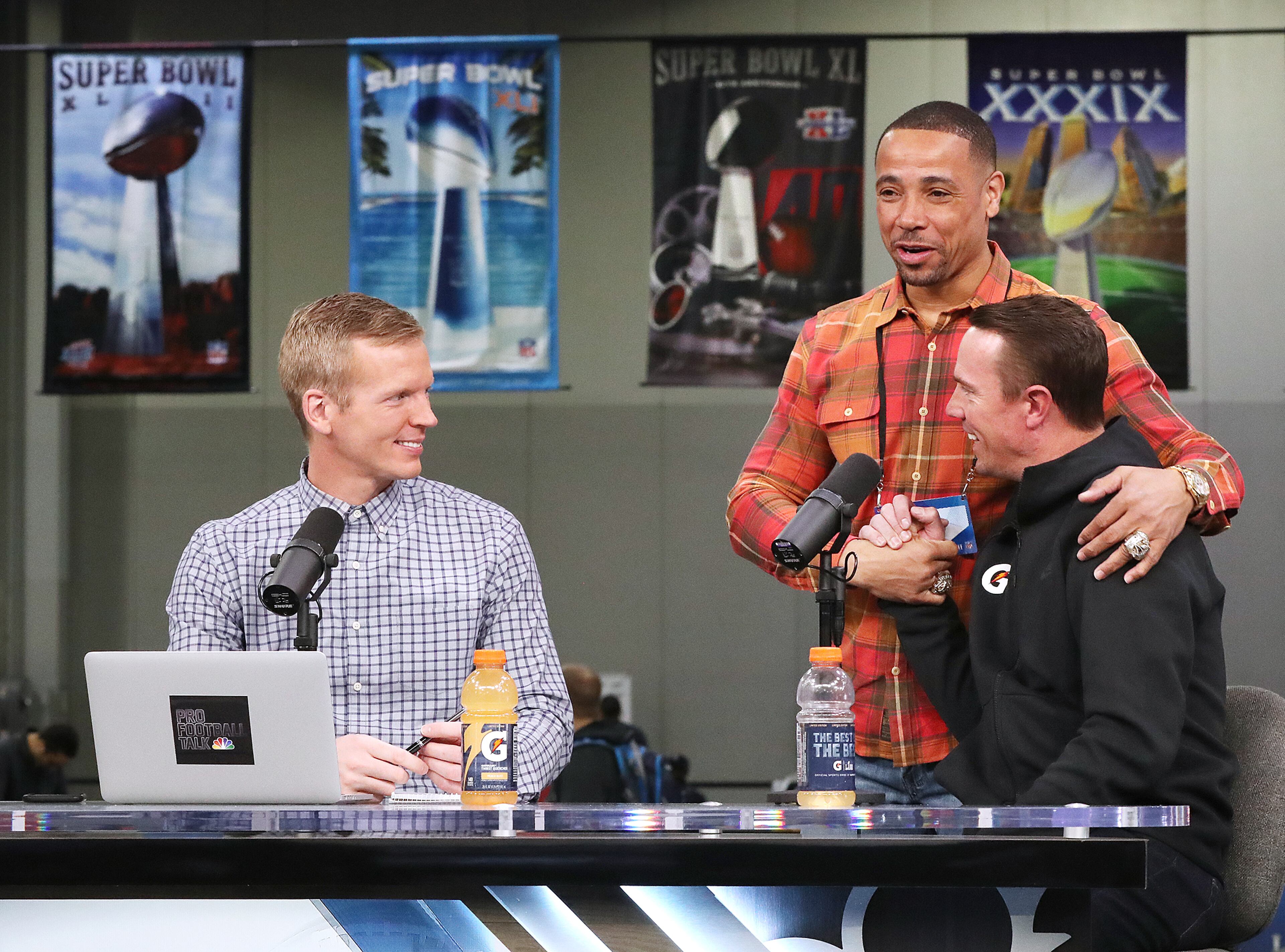 Jan. 31, 2019 Atlanta: Super Bowl banners hang from the ceiling as Atlanta Falcons quarterback Matt Ryan gets a hug from former Patriots safety Rodney Harrison while he is interviewed by former Tampa Bay quarterback Chris Sims on Pro Football Talk while making his rounds on radio row at the Georgia World Congress Center on Thursday, Jan. 31, 2019, in Atlanta. Curtis Compton/ccompton@ajc.com