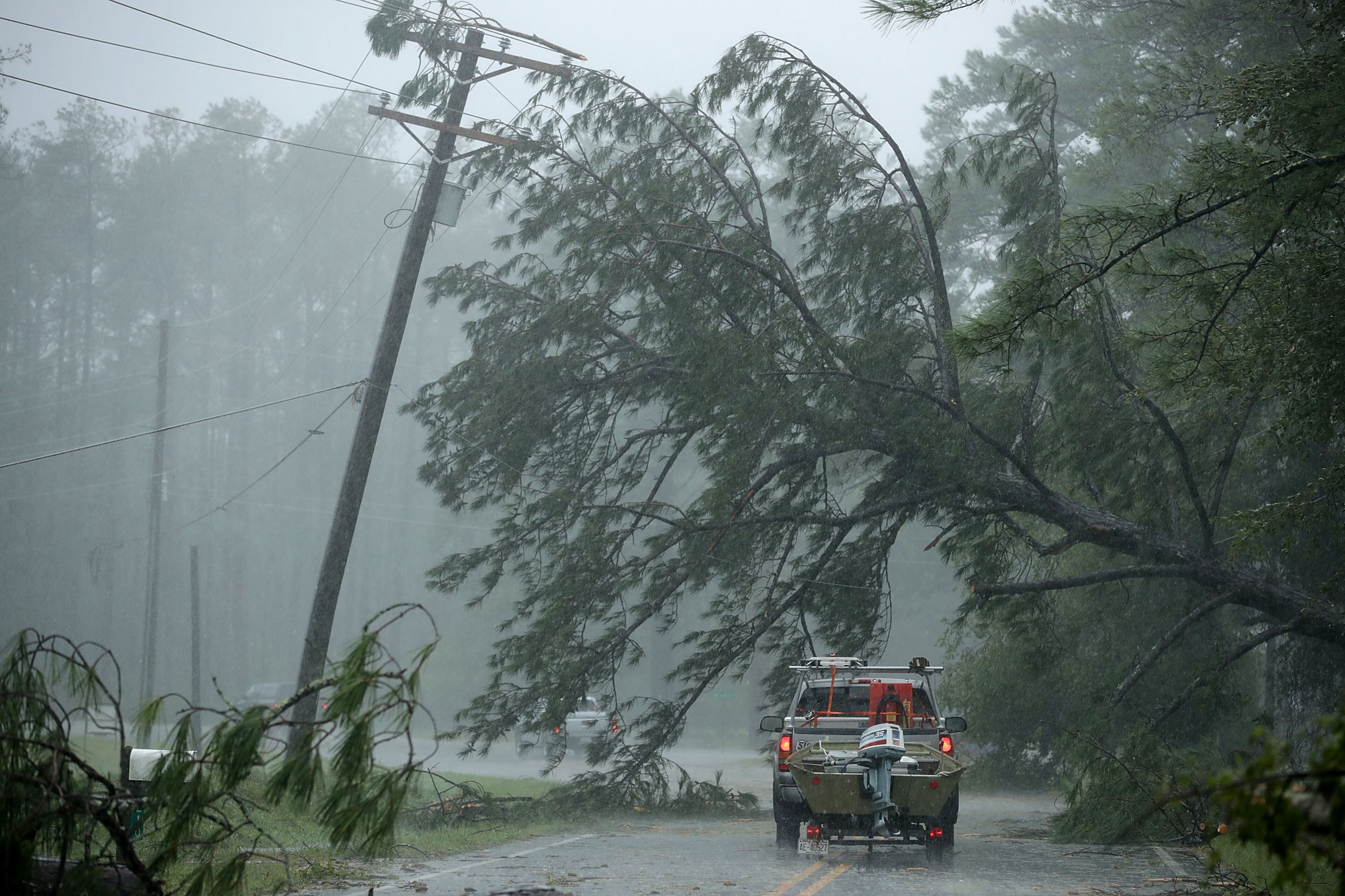 A volunteer rescue truck drives underneath a fallen tree that is suspended by power lines blown down by Hurricane Florence on Friday in New Bern, N.C. (Photo: Chip Somodevilla/Getty Images)