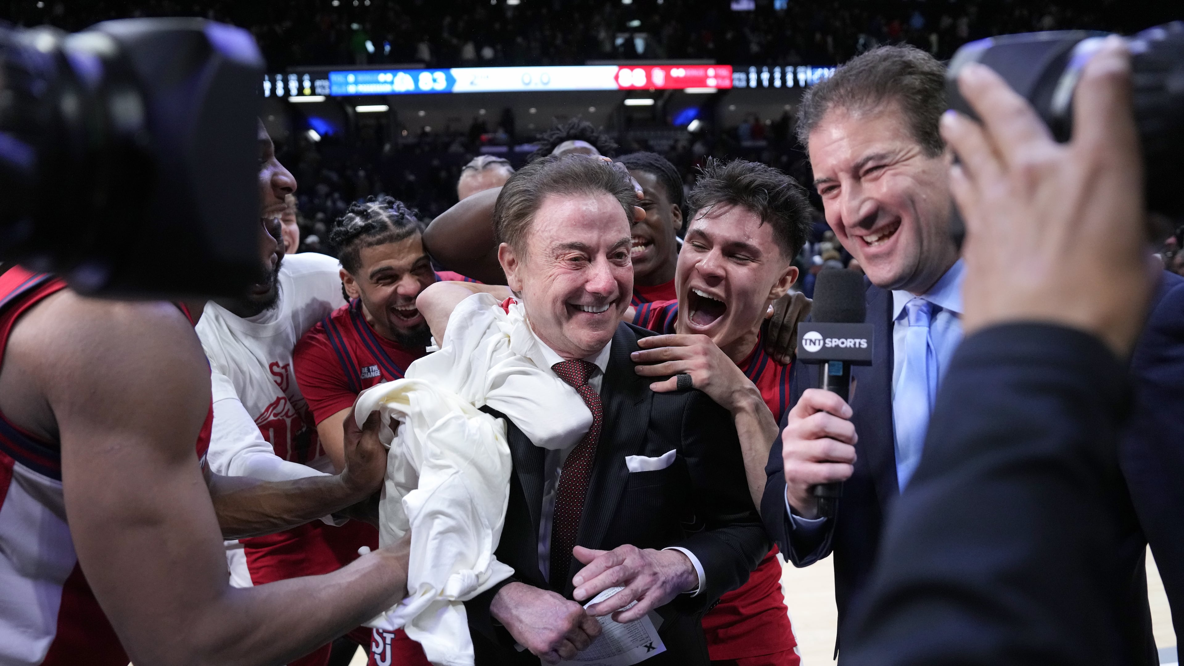 St. John's head coach Rick Pitino, center, is congratulated by his team after earning his 900th career coaching win against Xavier, Saturday, Jan. 24, 2026, in Cincinnati. (AP Photo/Kareem Elgazzar)