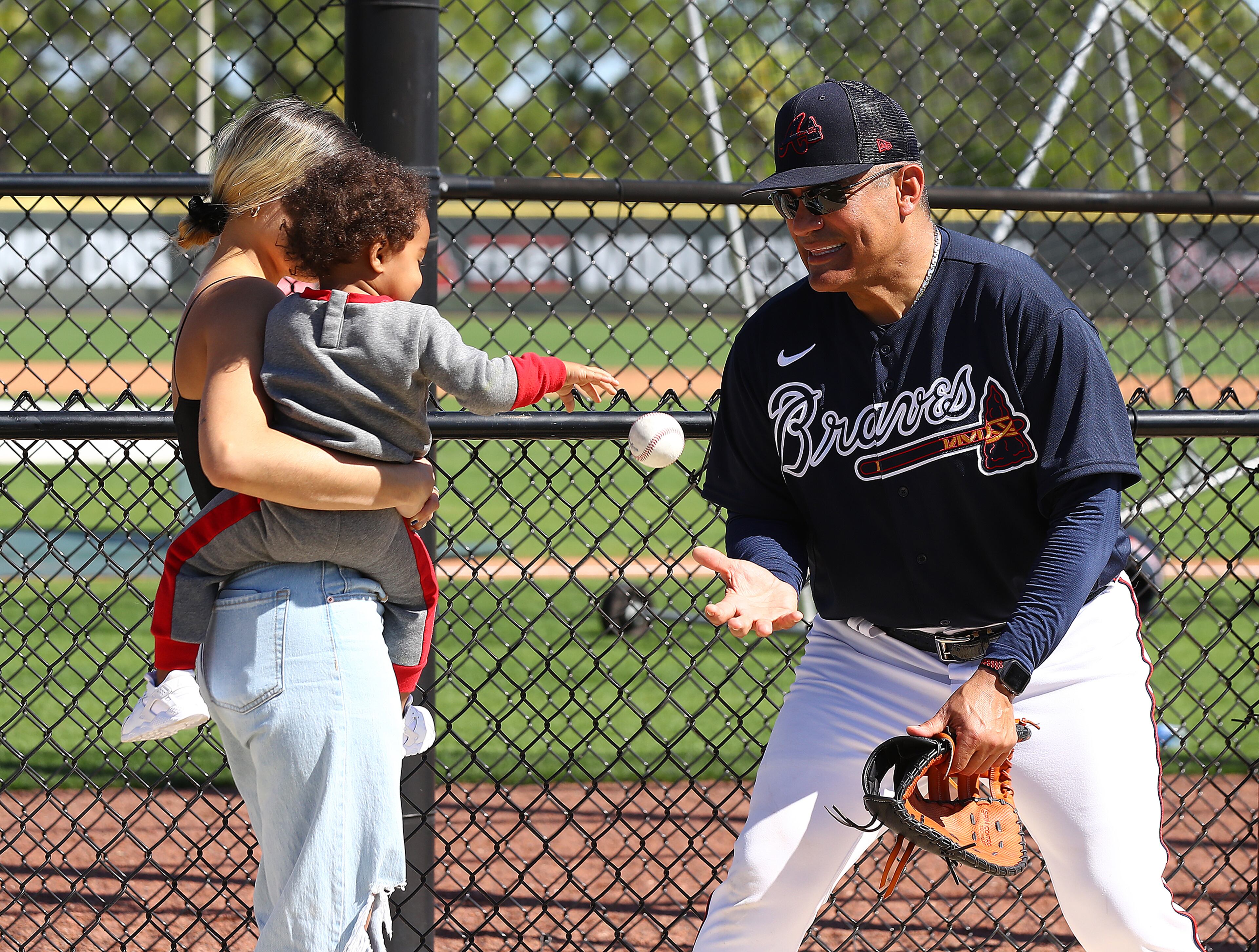 Braves coach Eddie Perez plays catch with Ronald Acuna Jr. II while his dad, outfielder Ronald Acuna takes batting practice during Spring Training on Thursday, March 17, 2022, in North Port. “Curtis Compton / Curtis.Compton@ajc.com”