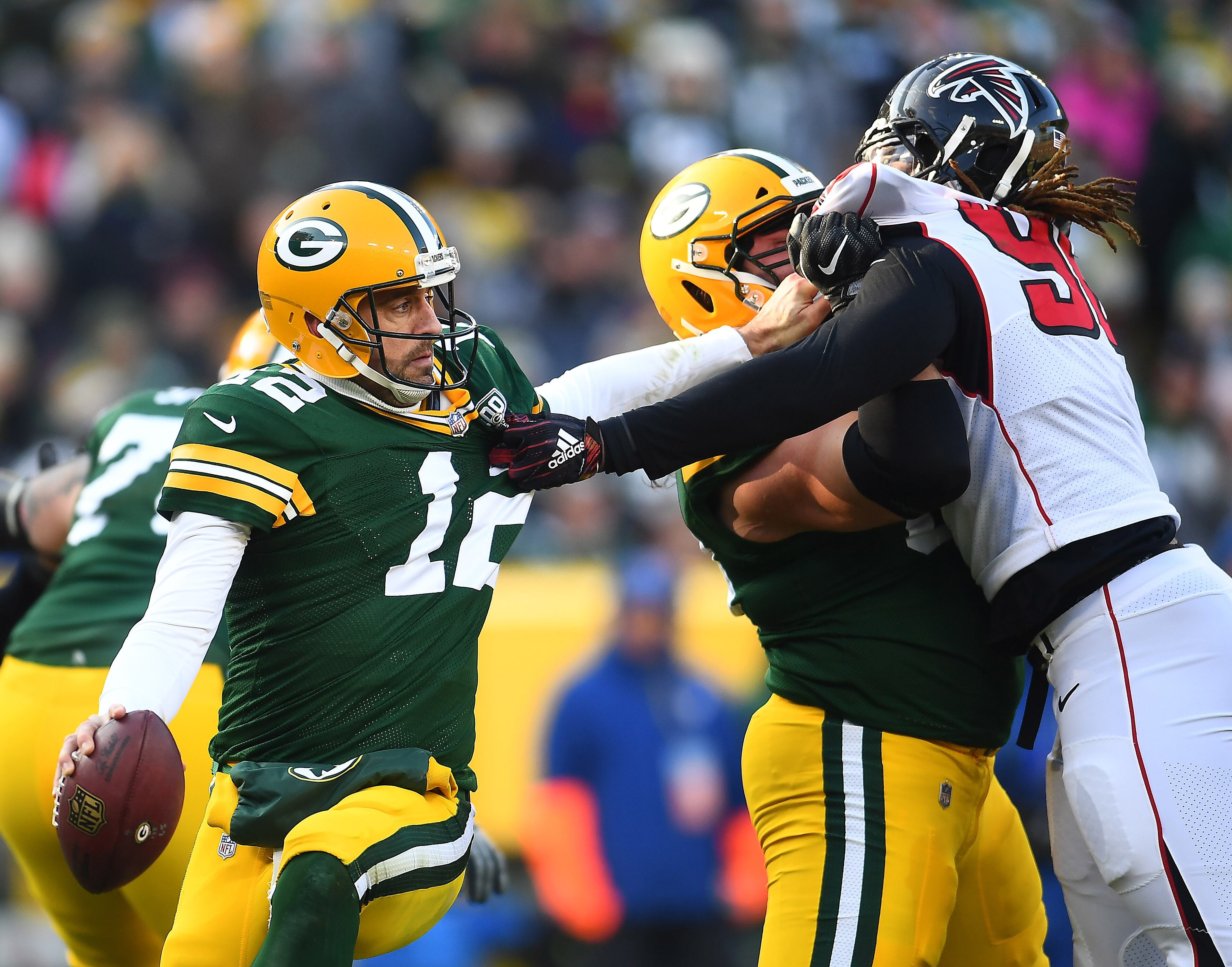 GREEN BAY, WISCONSIN - DECEMBER 09: Aaron Rodgers #12 of the Green Bay Packers attempts to get away from Takkarist McKinley #98 of the Atlanta Falcons during the first half of a game at Lambeau Field on December 09, 2018 in Green Bay, Wisconsin. (Photo by Stacy Revere/Getty Images)