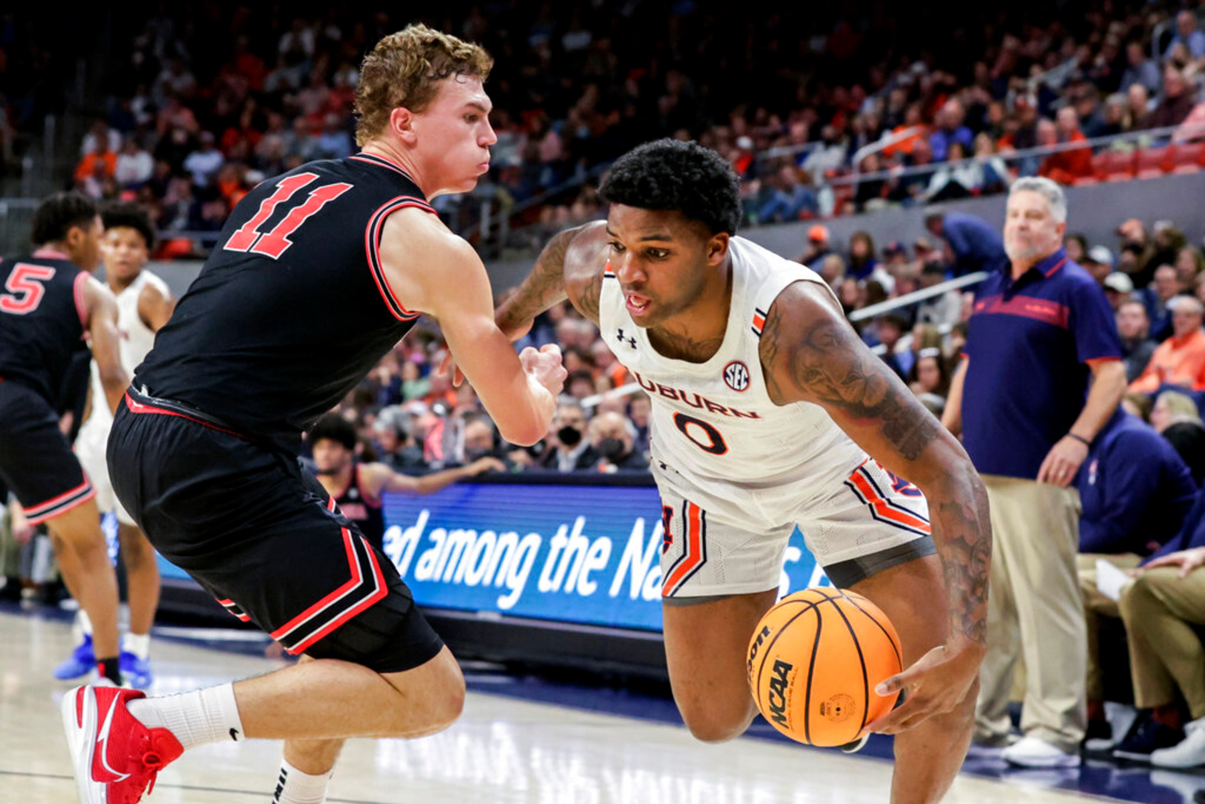 Auburn guard K.D. Johnson (0) drives the baseline around Georgia forward Jaxon Etter (11) during the second half of an NCAA college basketball game Wednesday, Jan. 19, 2022, in Auburn, Ala. (AP Photo/Butch Dill)