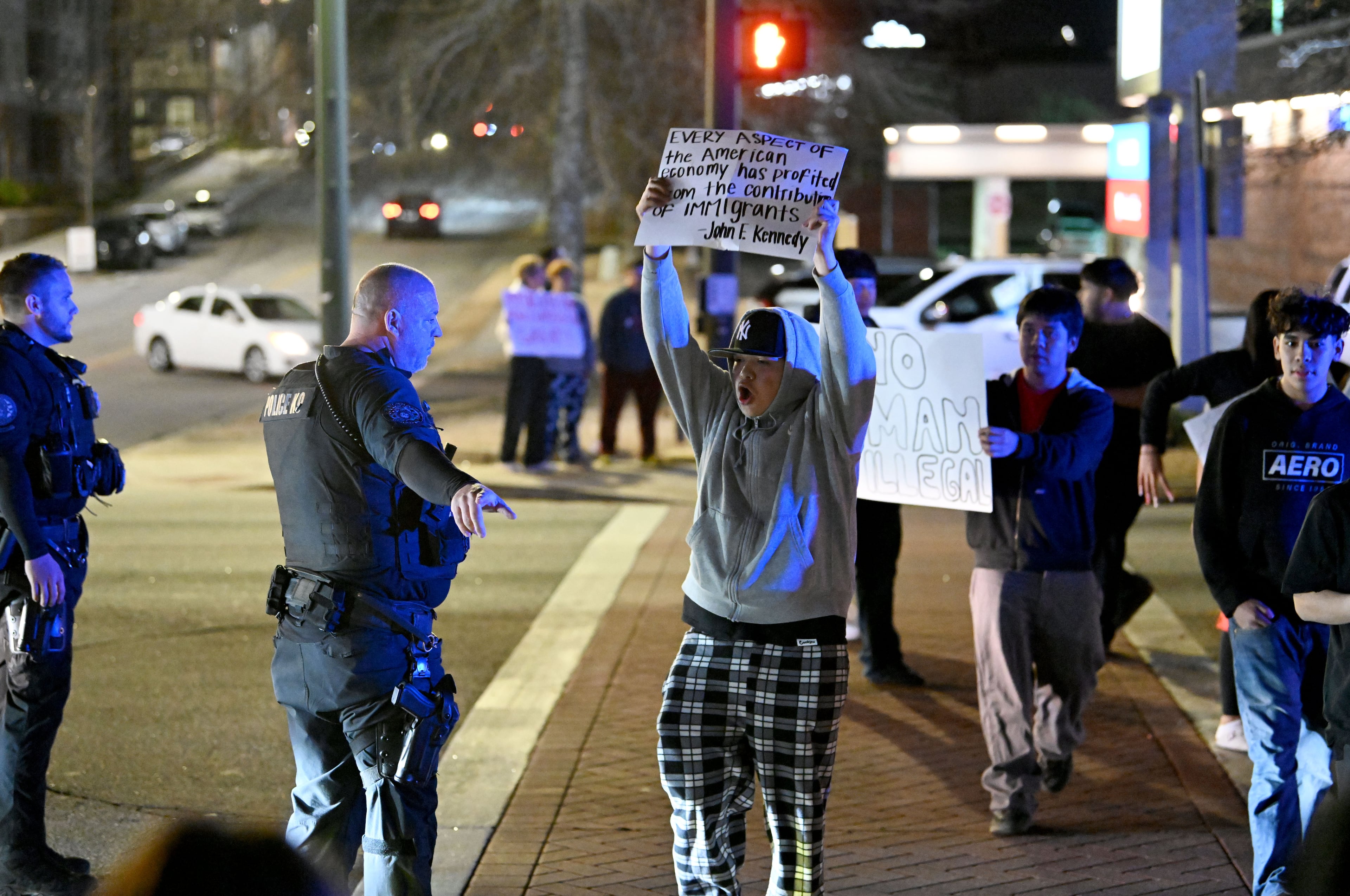 Police scuffles with protesters as they hold signs and chant in the middle of Jesse Jewell Parkway during a protest against ICE and deportations, Wednesday, January 29, 2025, in Gainesville. (Hyosub Shin / AJC)