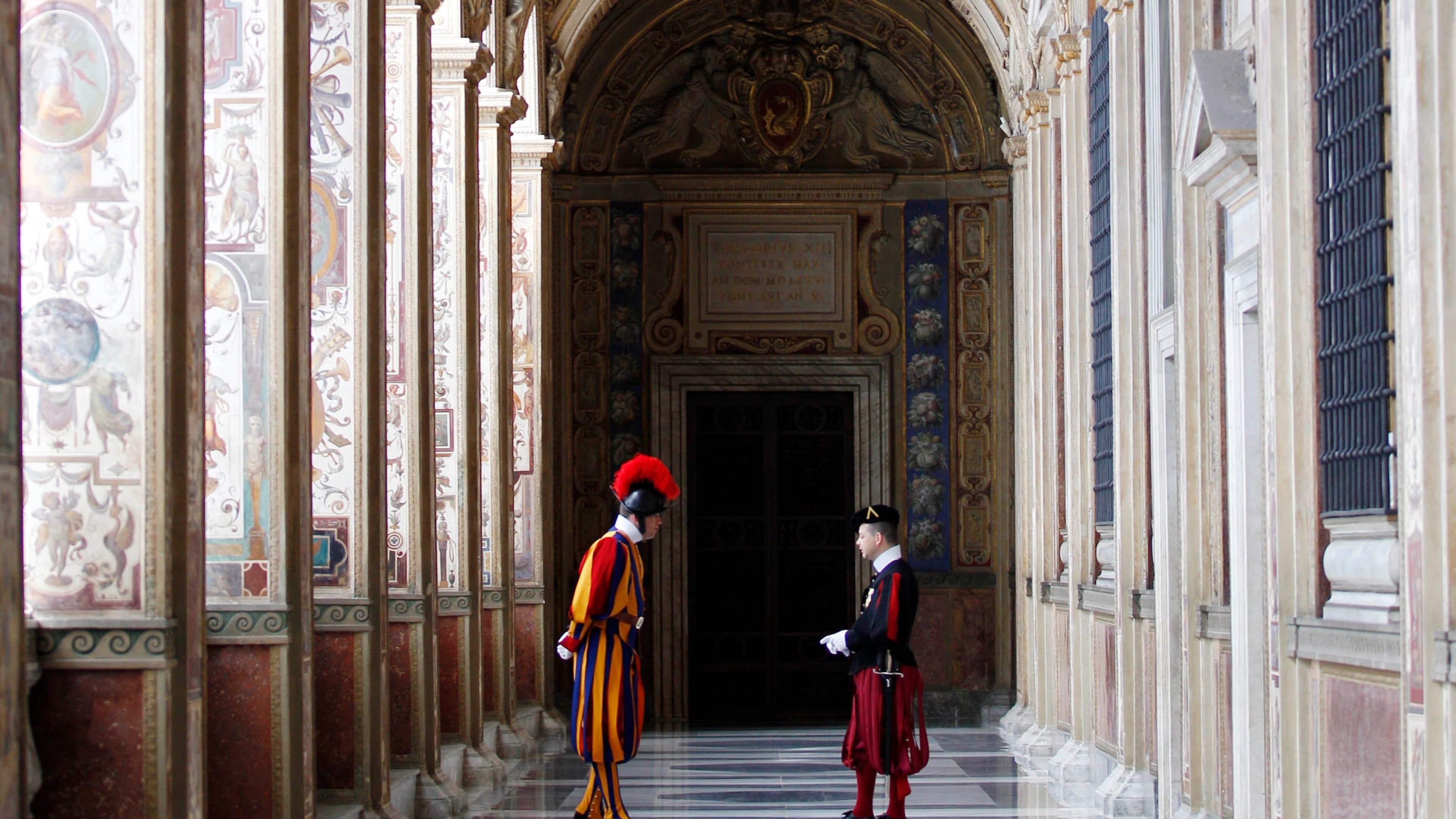 FILE - Swiss guards talk in a Vatican corridor prior to a private audience of Pope Francis to the Archbishop of Canterbury Justin Welby, at the Vatican Friday, June 14, 2013. (AP Photo/Alessandra Tarantino, file)