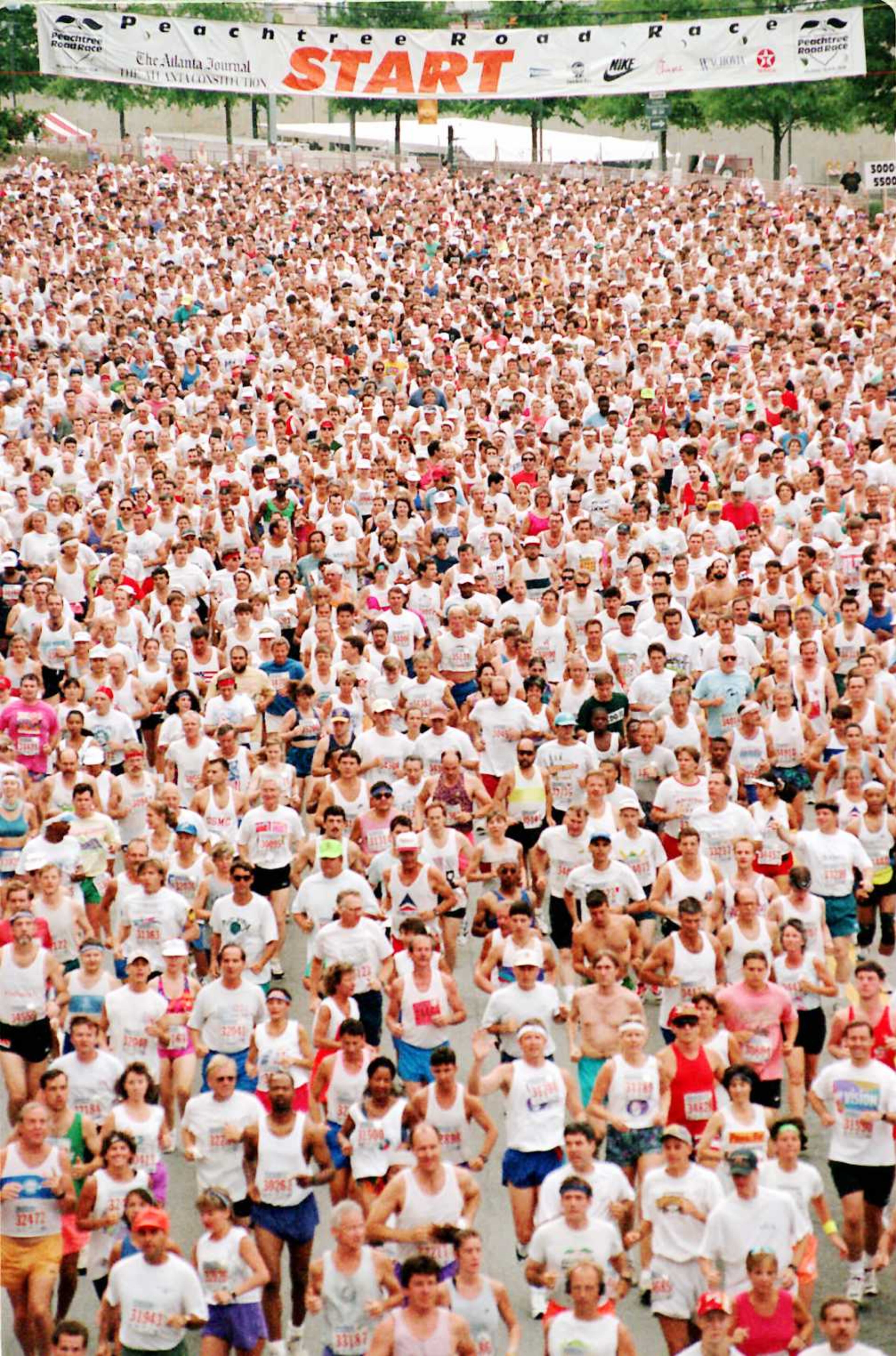 The 26th annual AJC Peachtree Road Race gets underway as some of the more than 50,000 athletes make their way down Peachtree Road at the Lenox Square starting line on July 4, 1995.