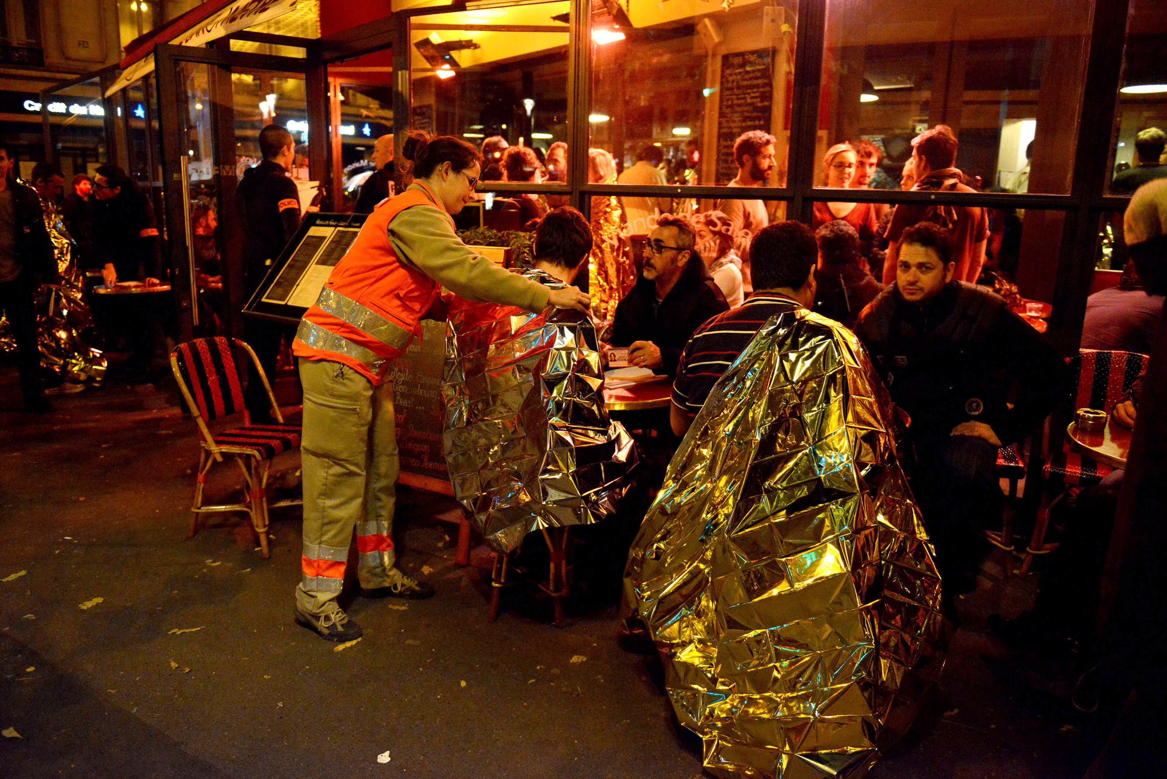 Survivors are tended to at a cafe after gunfire in the Bataclan concert hall on November 13, 2015 in Paris, France. According to reports, over 150 people were killed in a series of bombings and shootings across Paris, including at a soccer game at the Stade de France and a concert at the Bataclan theater. (Photo by Antoine Antoniol/Getty Images)