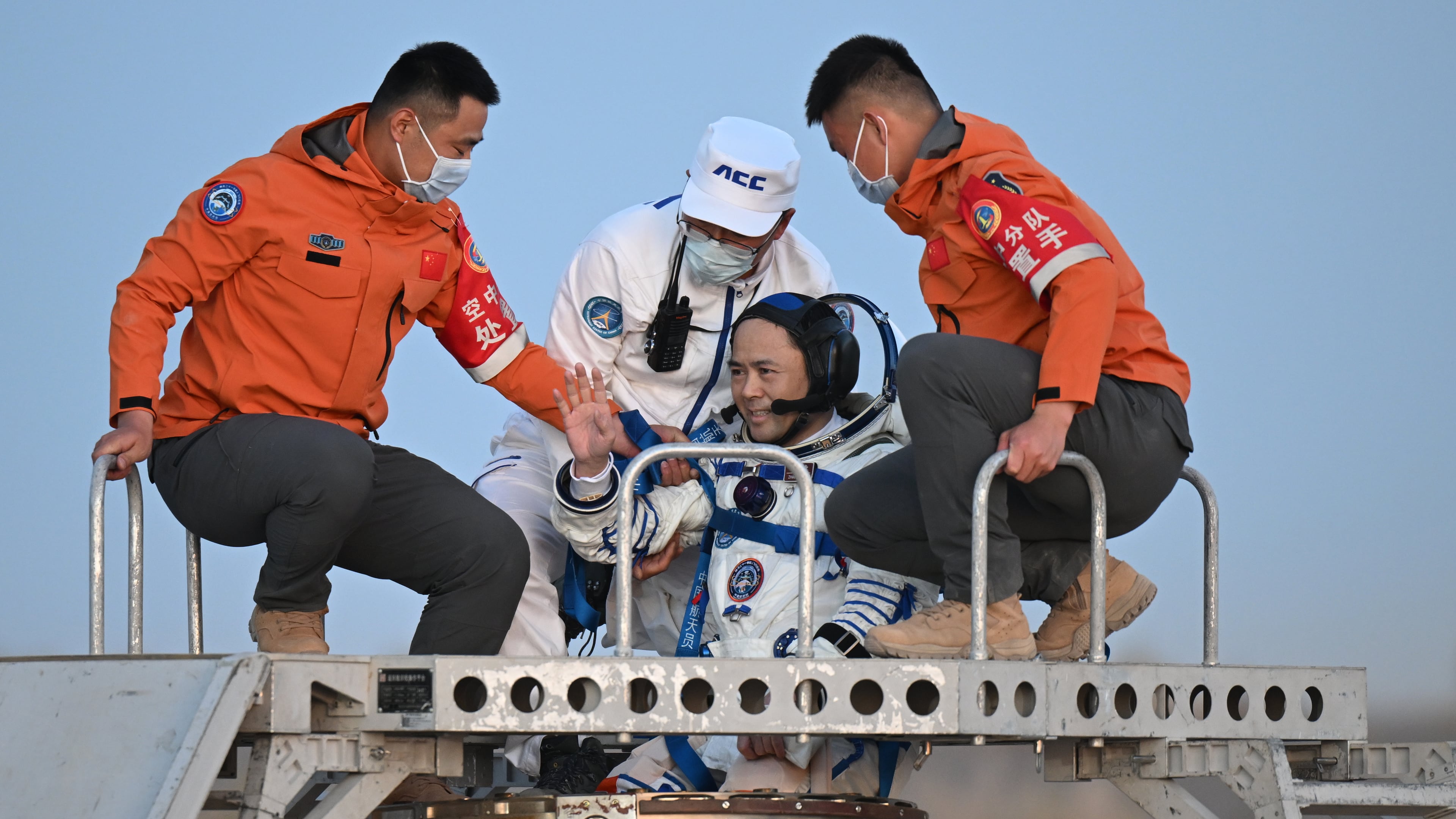 In this photo released by Xinhua News Agency, astronaut Zhang Lu, commander of Shenzhou-21 crews waves as he is carried out of the re-entry capsule after it landed successfully at the Dongfeng landing site in northern China's Inner Mongolia Autonomous Region on Friday, May 29, 2026. (Lian Zhen/Xinhua via AP)