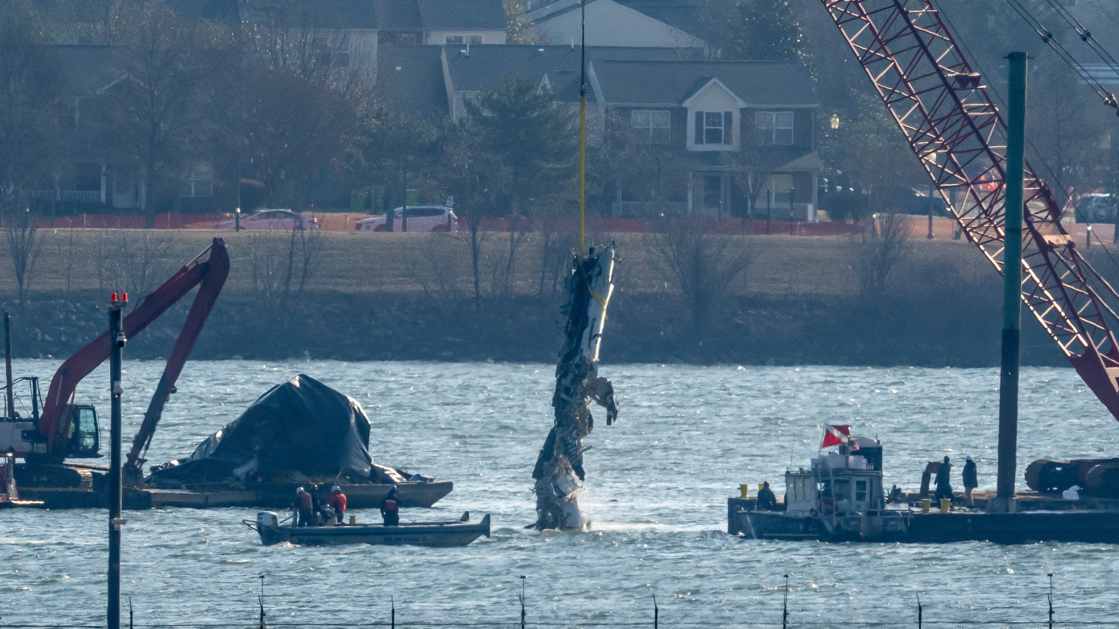 FILE - A piece of wreckage is lifted from the water onto a salvage vessel near the site in the Potomac River of a mid-air collision between an American Airlines jet and a Black Hawk helicopter, at Ronald Reagan Washington National Airport, Feb. 4, 2025, in Arlington, Va. (AP Photo/Ben Curtis, File)