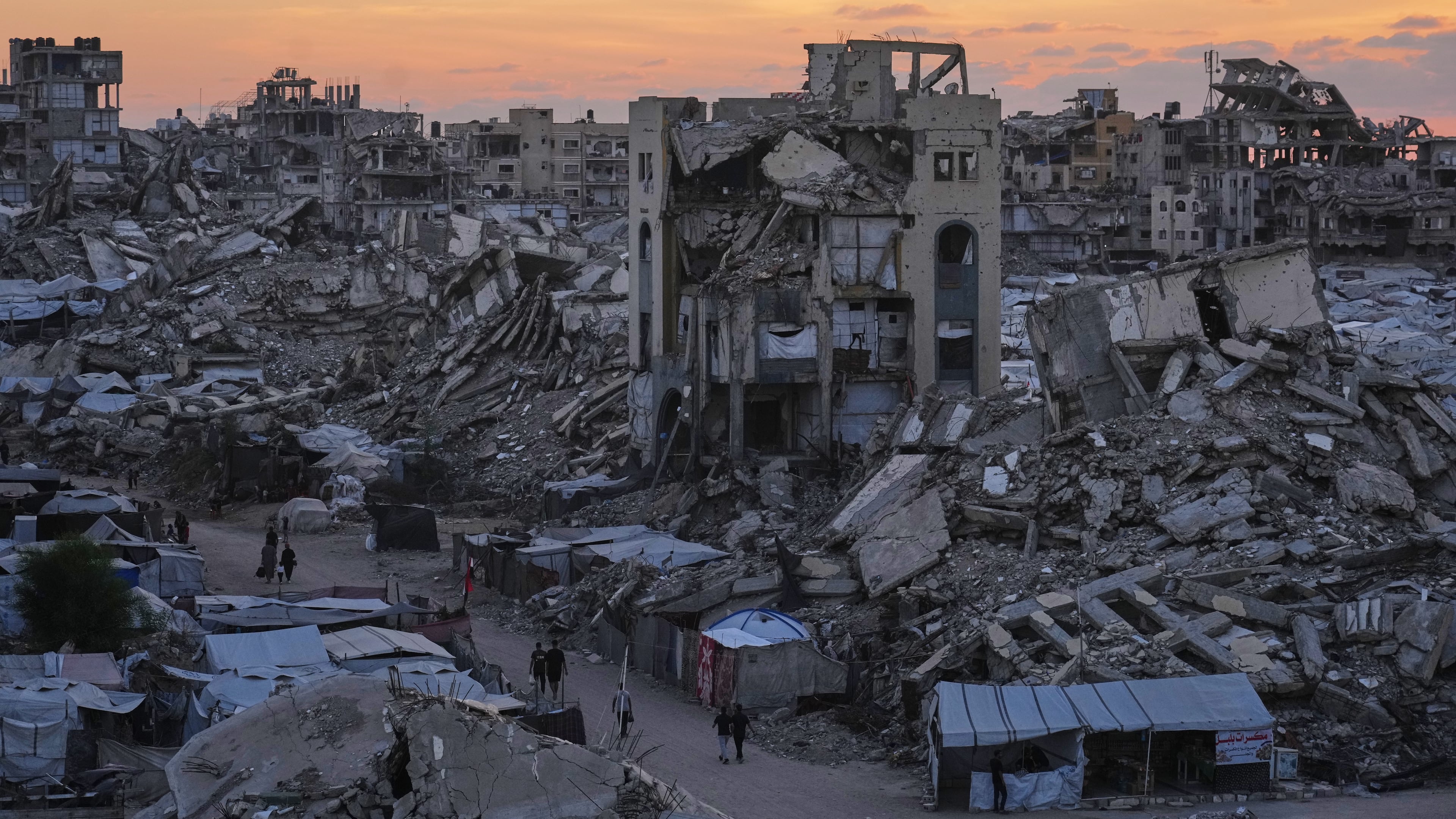 Palestinians walk amid war-damaged buildings in Gaza City, Wednesday, Sept. 23, 2026. (AP Photo/Jehad Alshrafi)