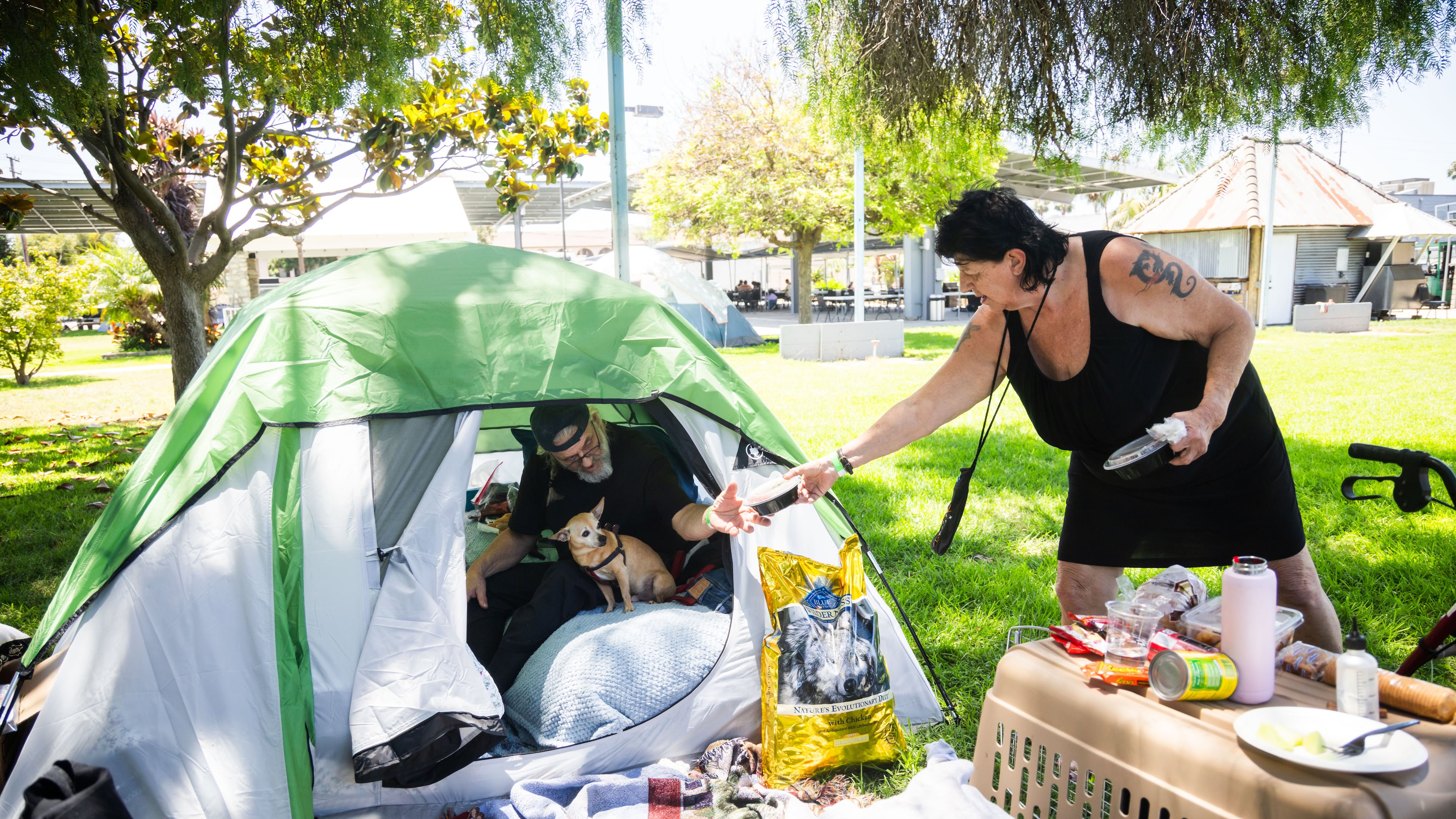 Jan De Jonge and fiancé Sher Stuckman set up a tent with their belonging and pet outside the Elks Lodge in Garden Grove, Calif., on Monday, May 25, 2026. (AP Photo/Ethan Swope)