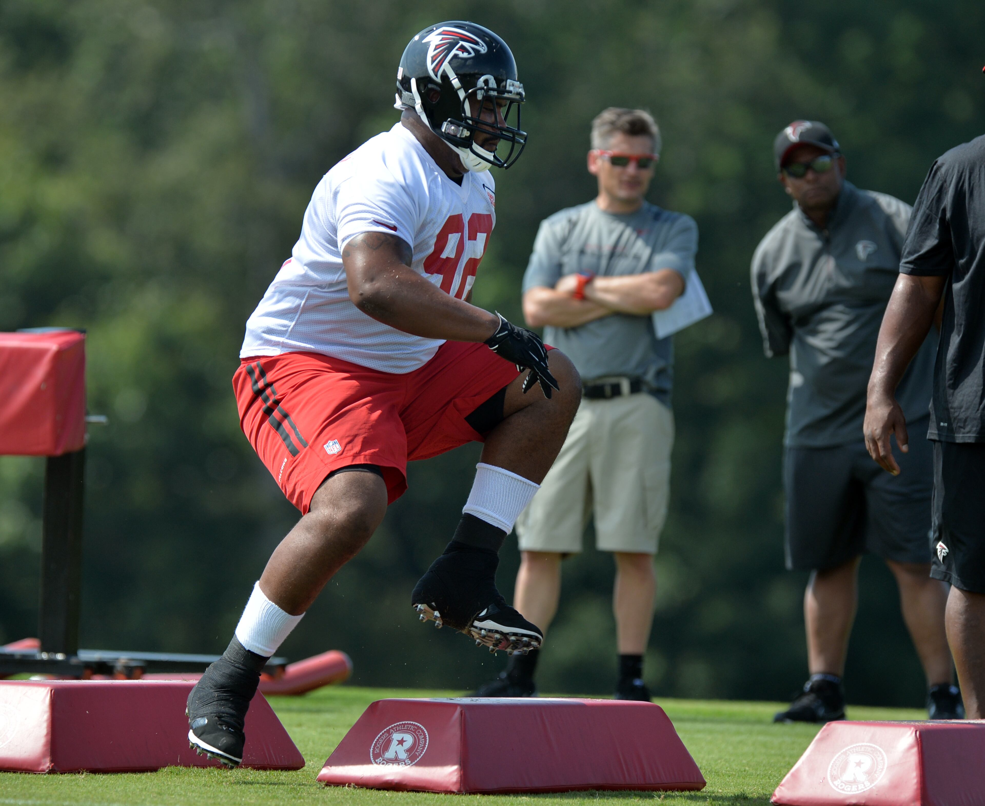 Atlanta Falcons nose tackle Travian Robertson runs a drill in front of GM Thomas Dimitroff on Friday, July 25, 2014.
