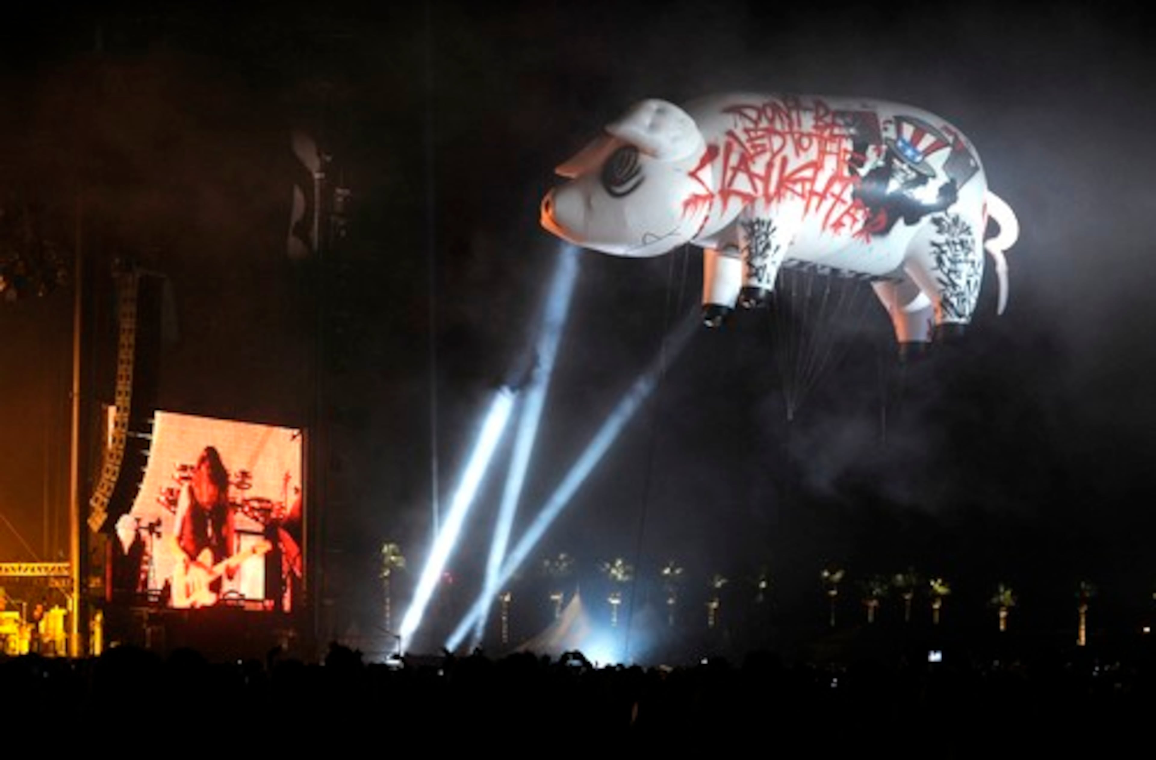 A giant inflatable pig scrawled with the words 'Don't Be Led To the Slaughter' floats over the crowd during Roger Waters' performance, which included playing all of 'Dark Side of the Moon.'