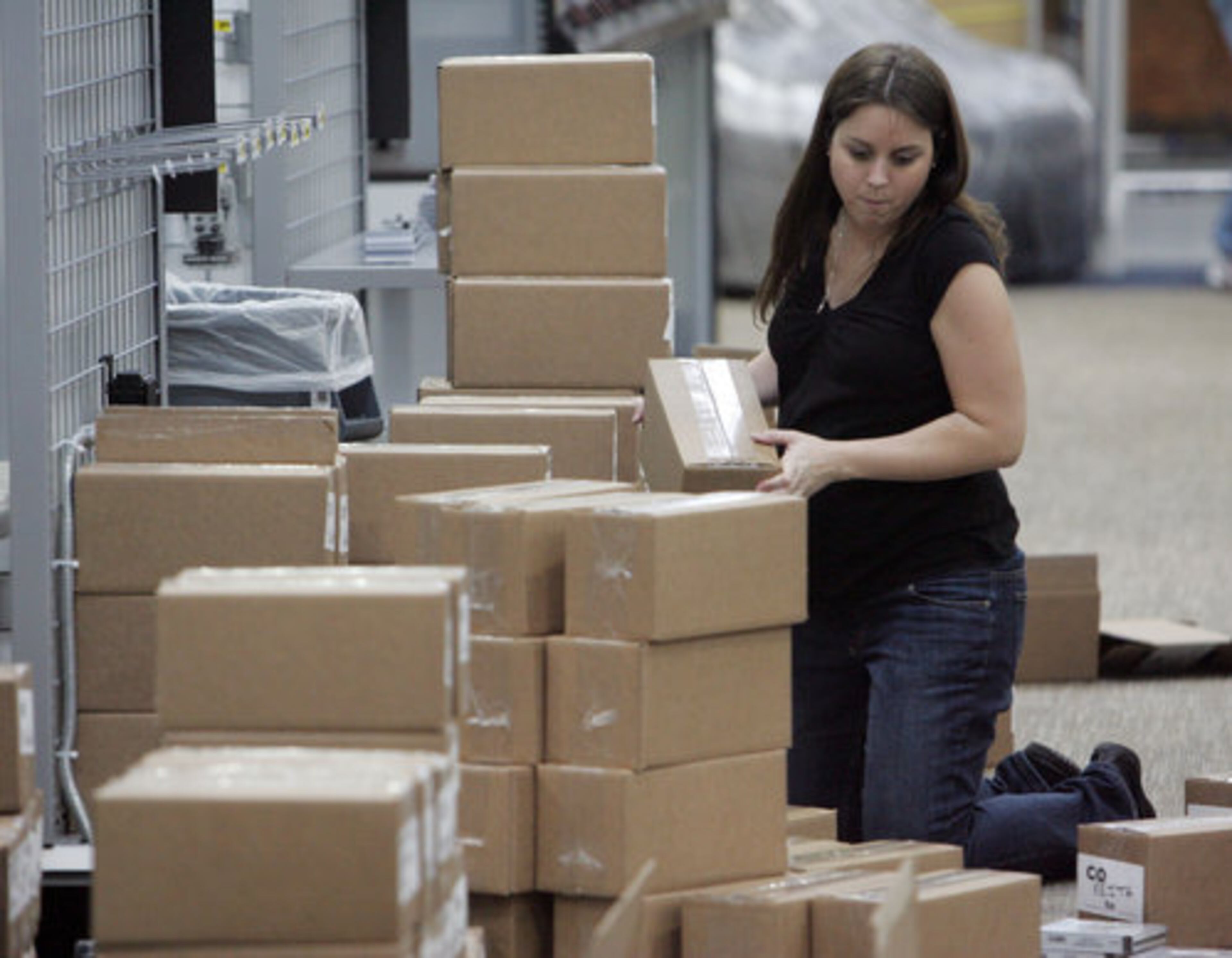Melanie Bean unpacks boxes as she stocks shelves at the new Best Buy store which is scheduled to open on February 27th at the Canton Marketplace.