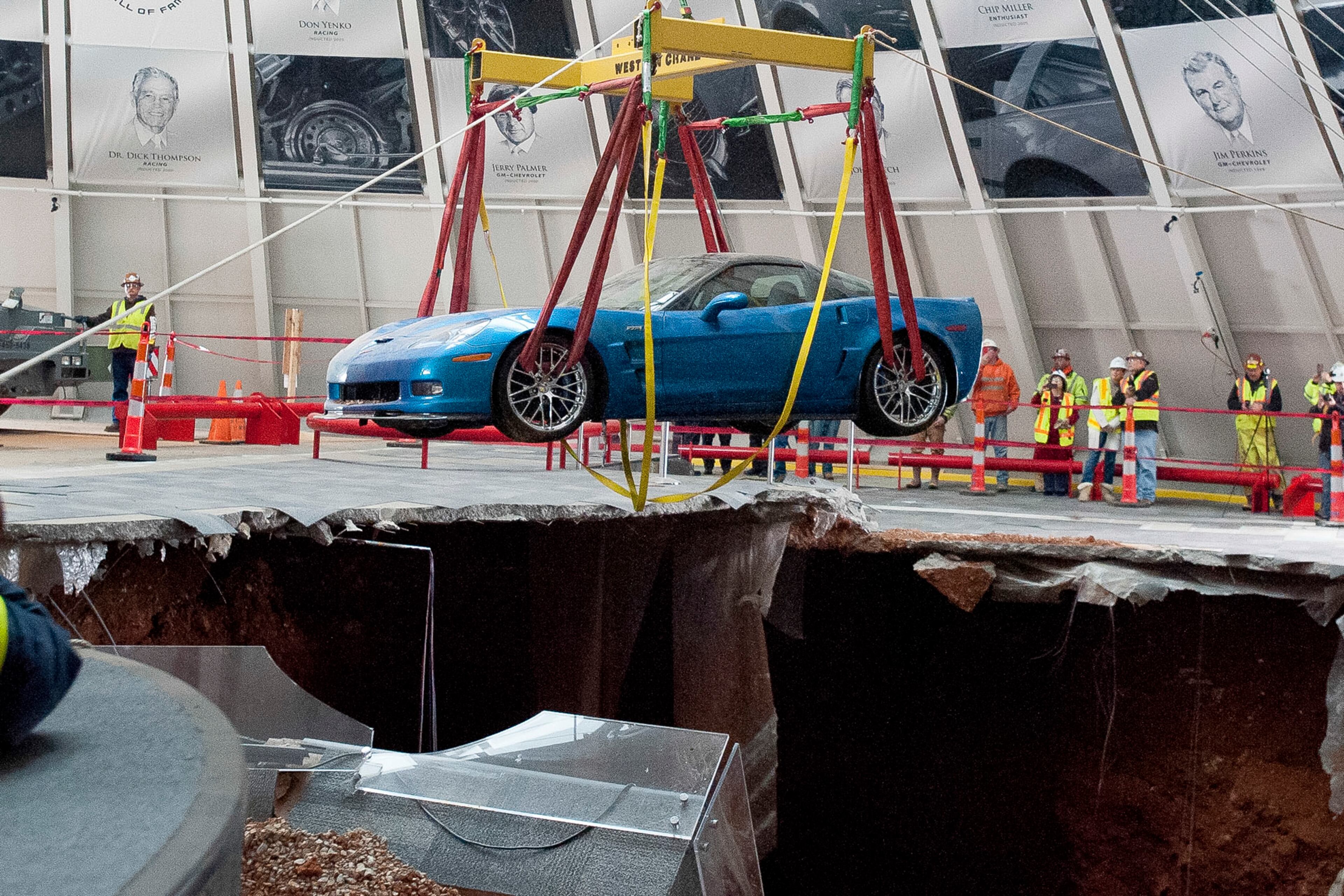 One of eight Chevrolet Corvettes is removed from a sinkhole in the Skydome at the National Corvette Museum, Monday, March. 3, 2014, in Bowling Green, Ky. On Feb. 12, a large sinkhole swallowed eight prized cars like they were toys, piling them in a heap amid loose dirt and concrete fragments. (AP Photo/Daily News, Alex Slitz)
