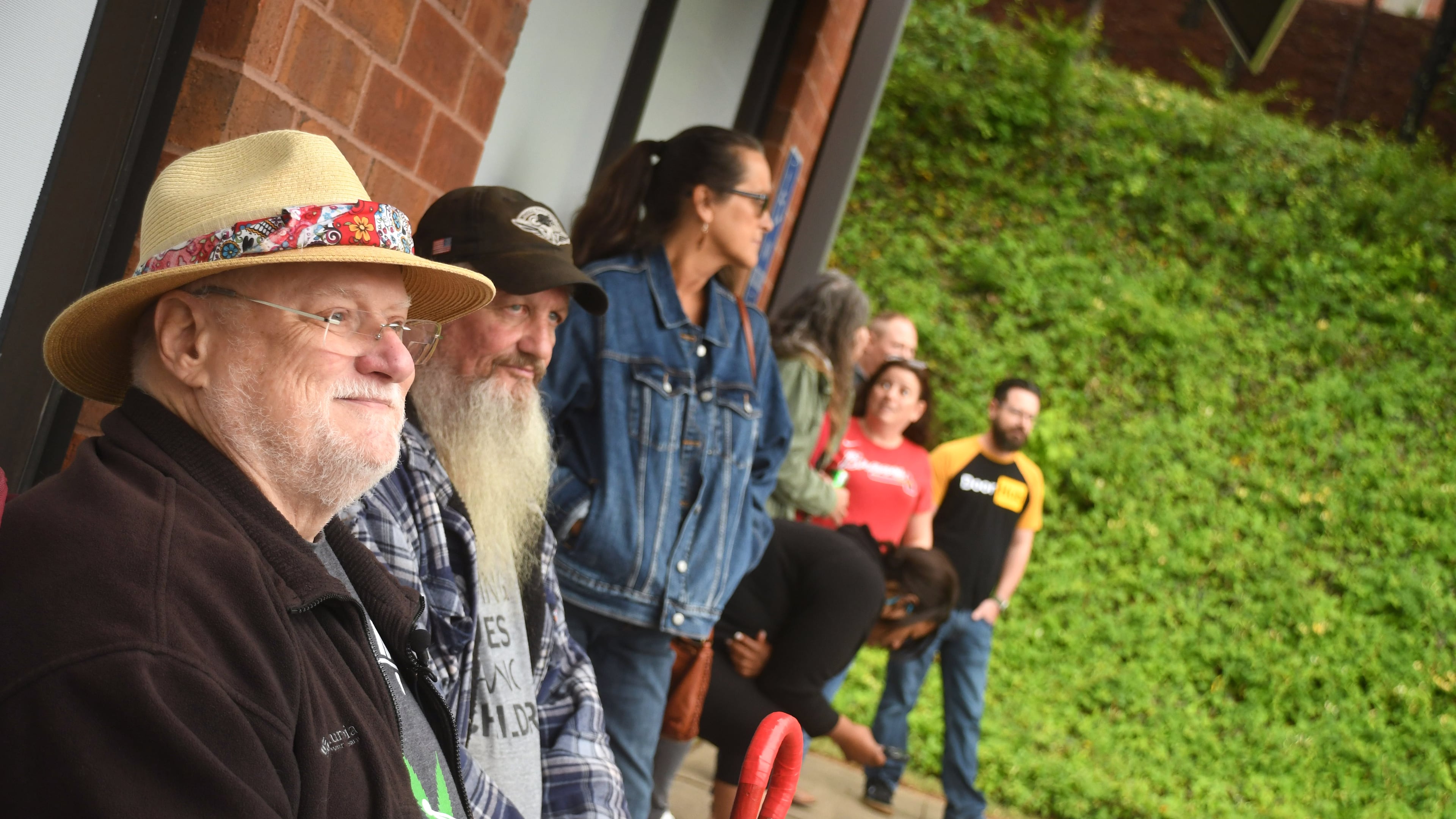 In this file photo, Ken Moore, of Woodstock, (left) and Les Wilson, of Powder Springs, (center) wait for Trulieve Medical Marijuana Dispensary to open up in Marietta on Friday April 28, 2023. Georgia's first medical marijuana dispensaries opened today in Marietta and in Macon. (Photo by Rebecca Breyer/freelance photographer)