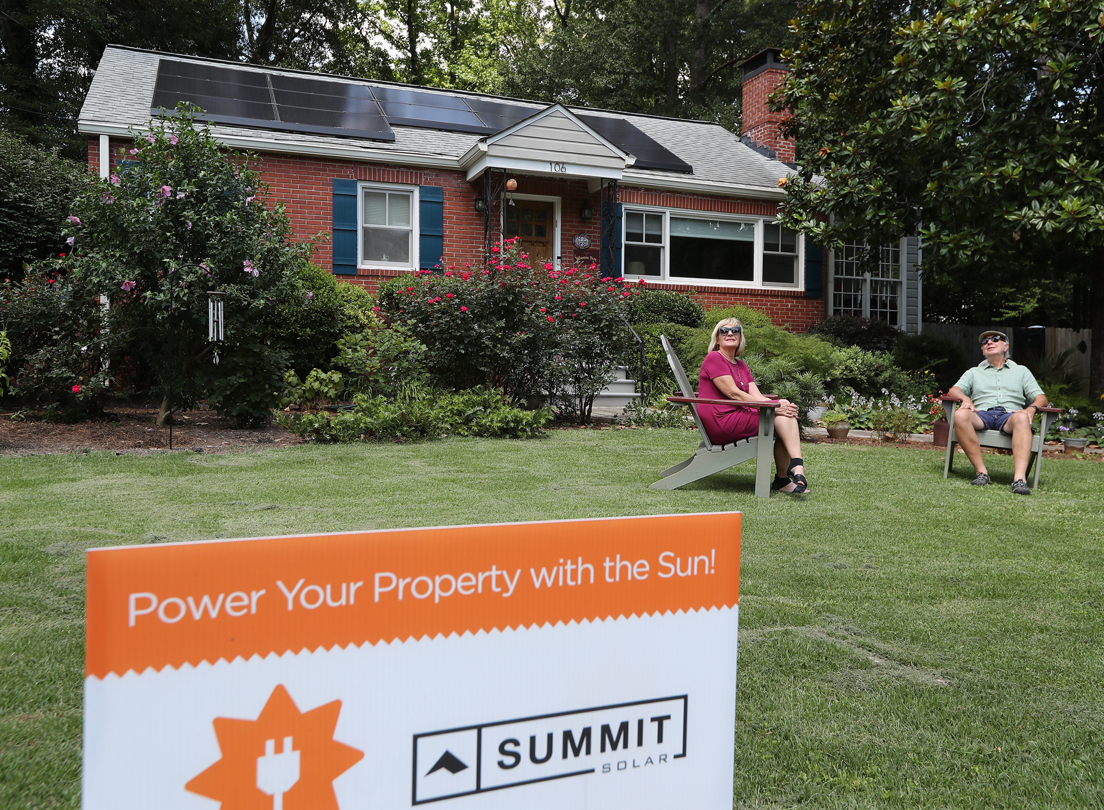 Patti and Gary Garrett, relaxing in their front yard, have 13 newly installed solar panels on the roof of their home on Tuesday July 14, 2020 in Decatur. CURTIS COMPTON / AJC